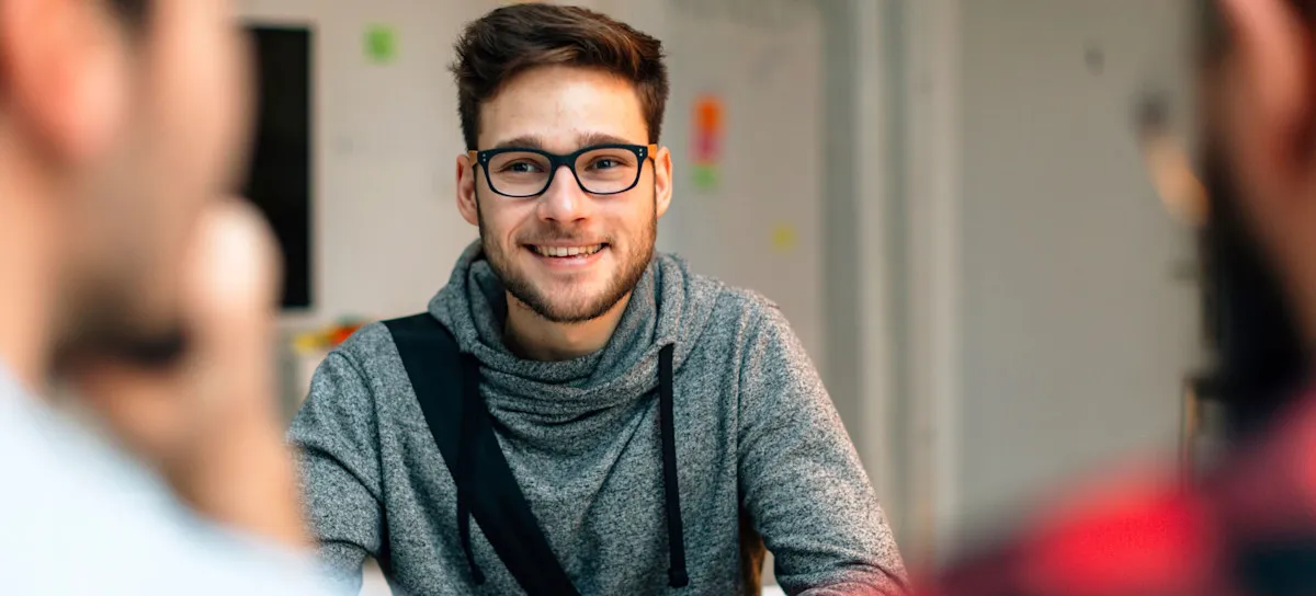 [Featured Image] A person in an entry-level job is talking to two other coworkers. 