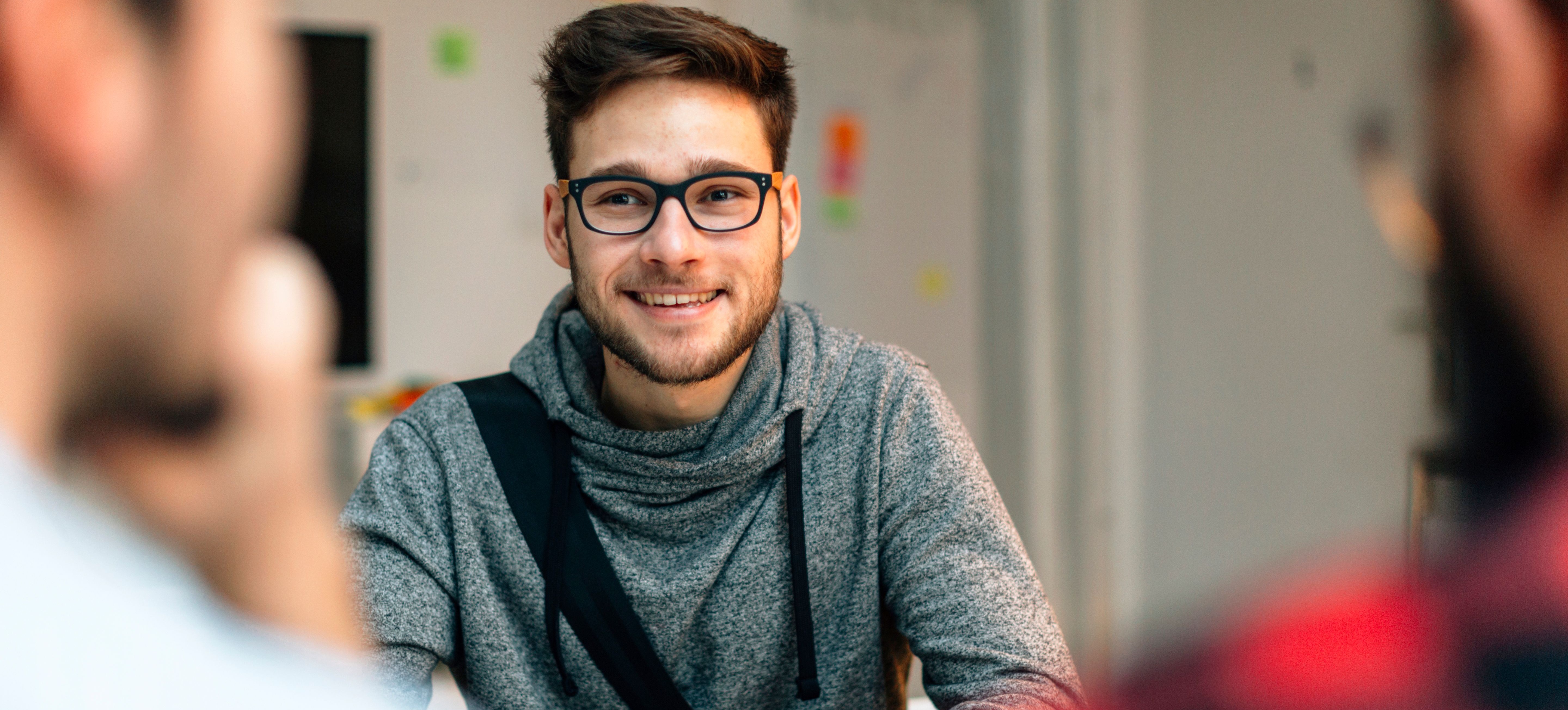 [Featured Image] A person in an entry-level job is talking to two other coworkers. 