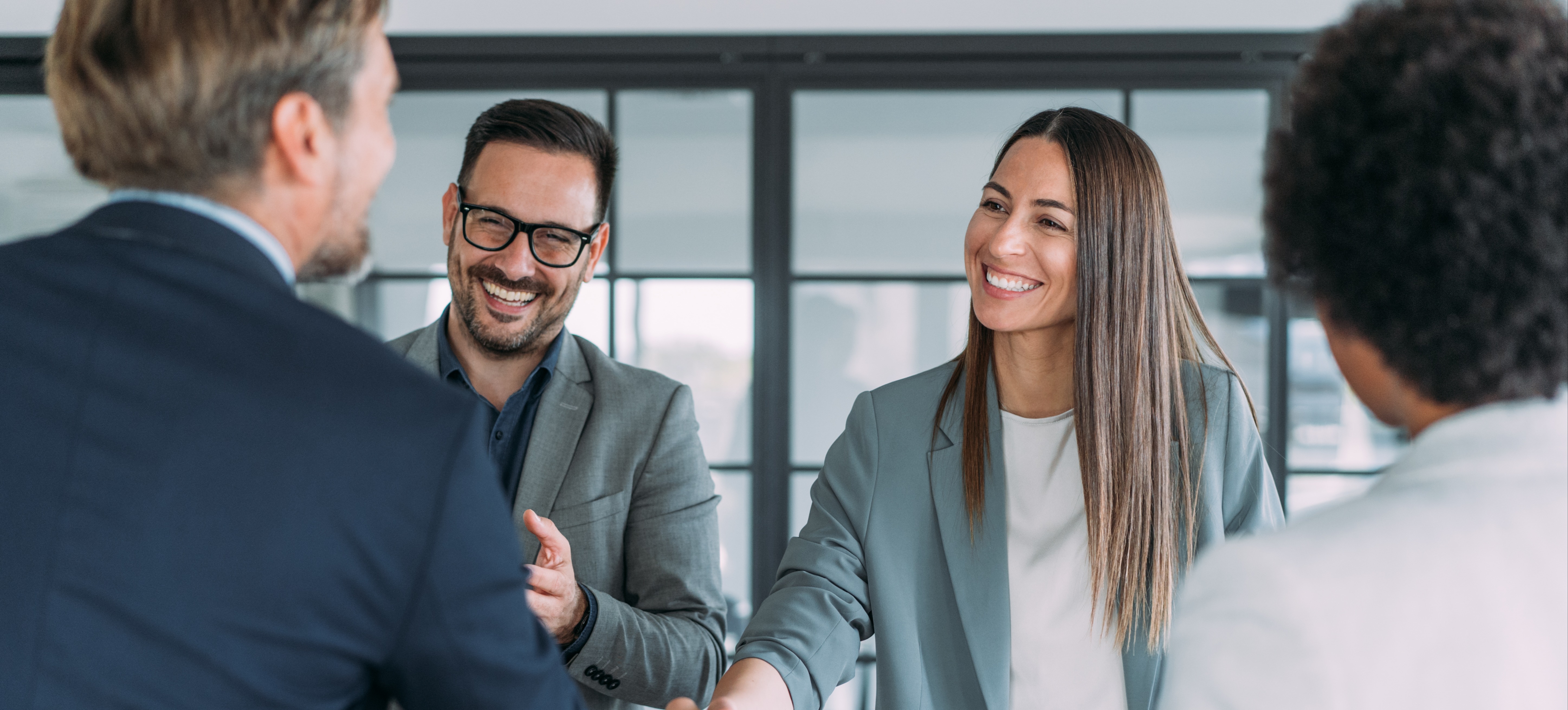 [Featured Image] A certified corporate recruiter is shaking hands with a potential client.
