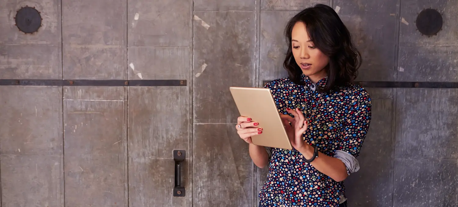 [Featured Image] A project manager checks the team's progress on their tablet.