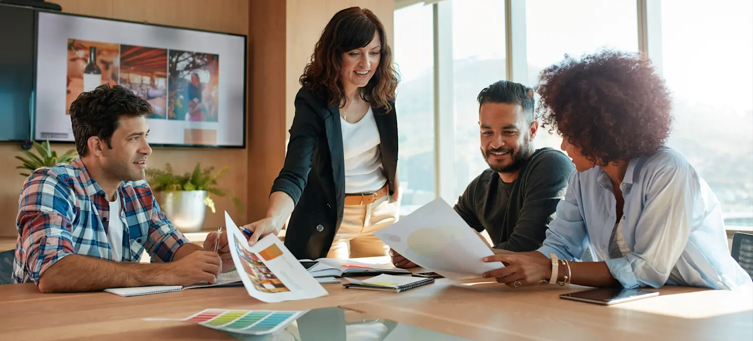 [Featured image] A growth marketing manager meets with their team in a conference room to discuss a new project to acquire new customers. 
