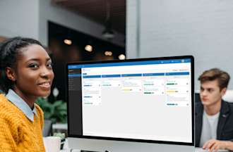 [Featured Image]:  IT Business Analyst, working at a desktop computer, evaluating the company's current technology. 