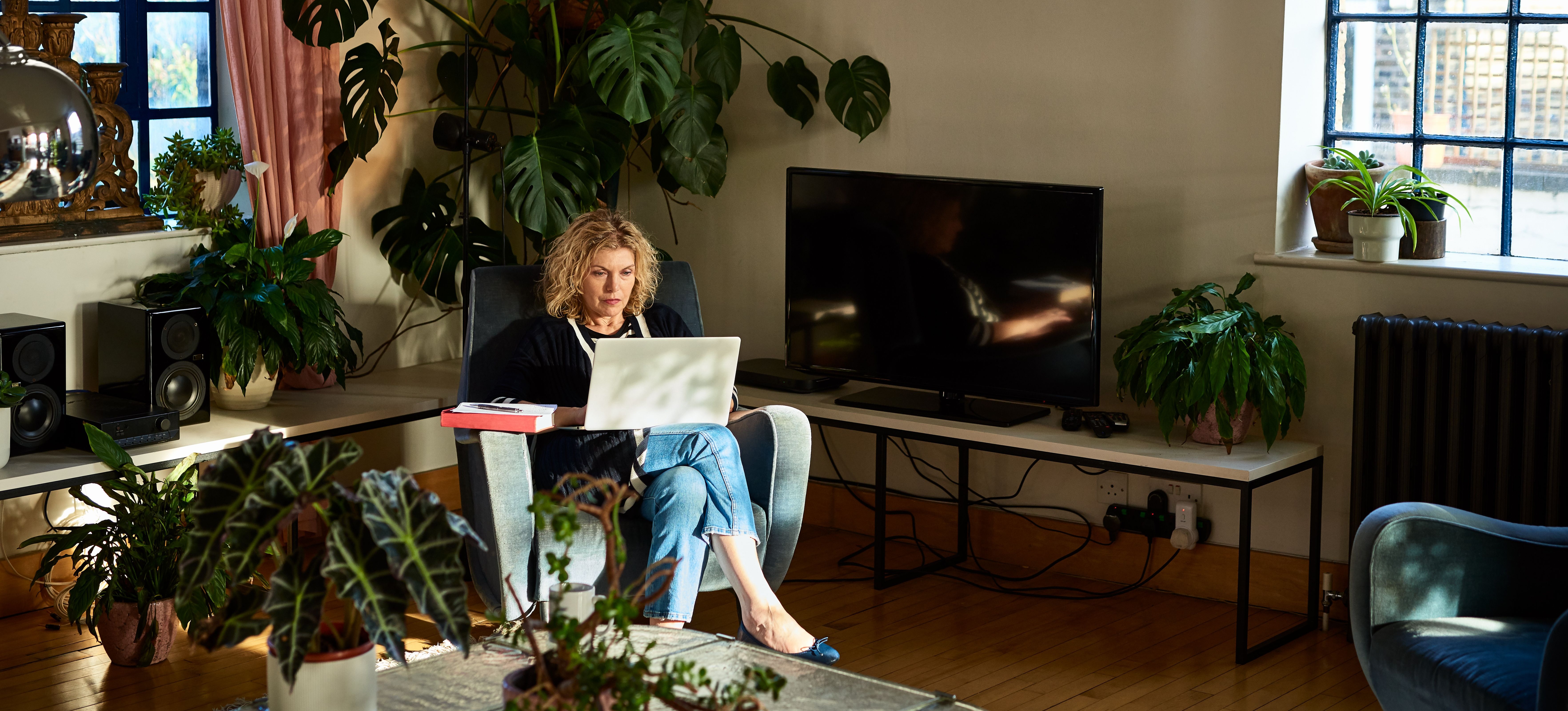 [Featured image] A student is learning about domain name systems on their laptop in their living room.