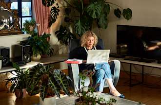 [Featured image] A student is learning about domain name systems on their laptop in their living room.