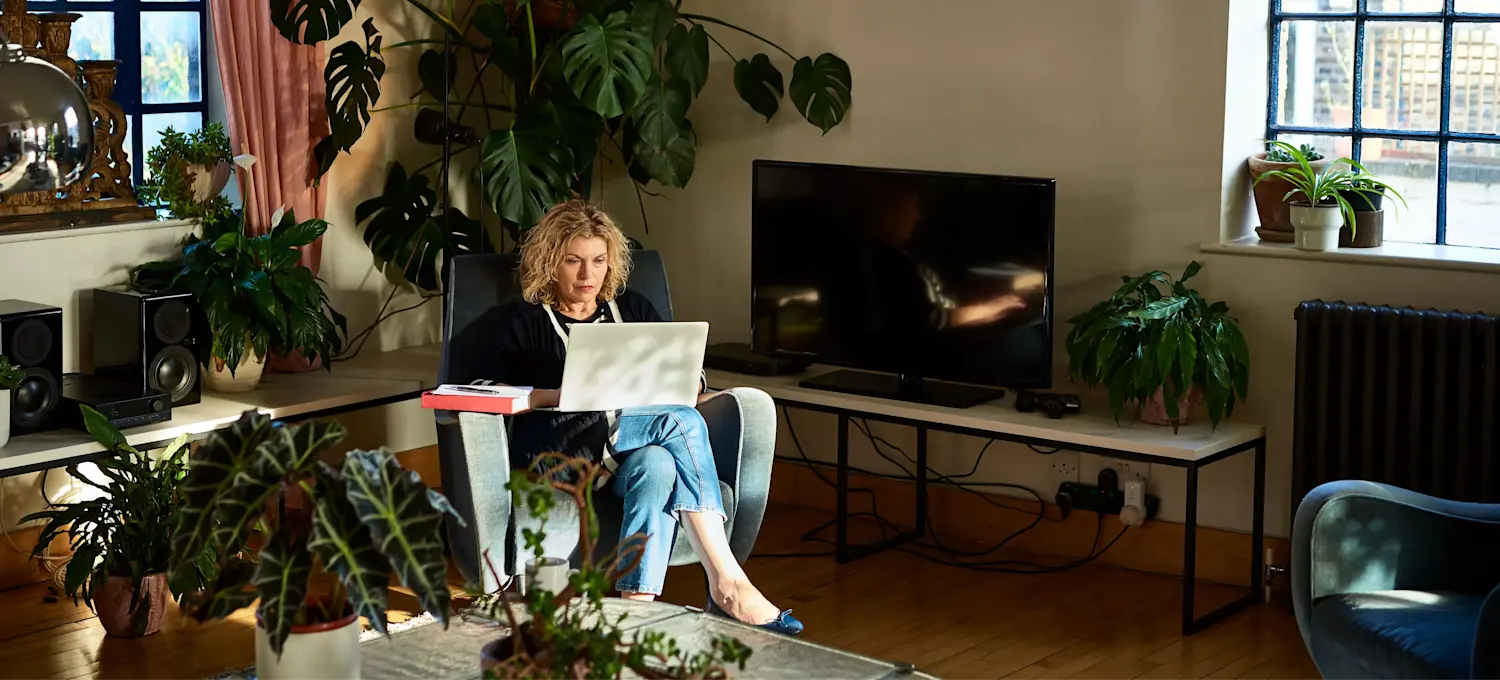 [Featured image] A student is learning about domain name systems on their laptop in their living room.