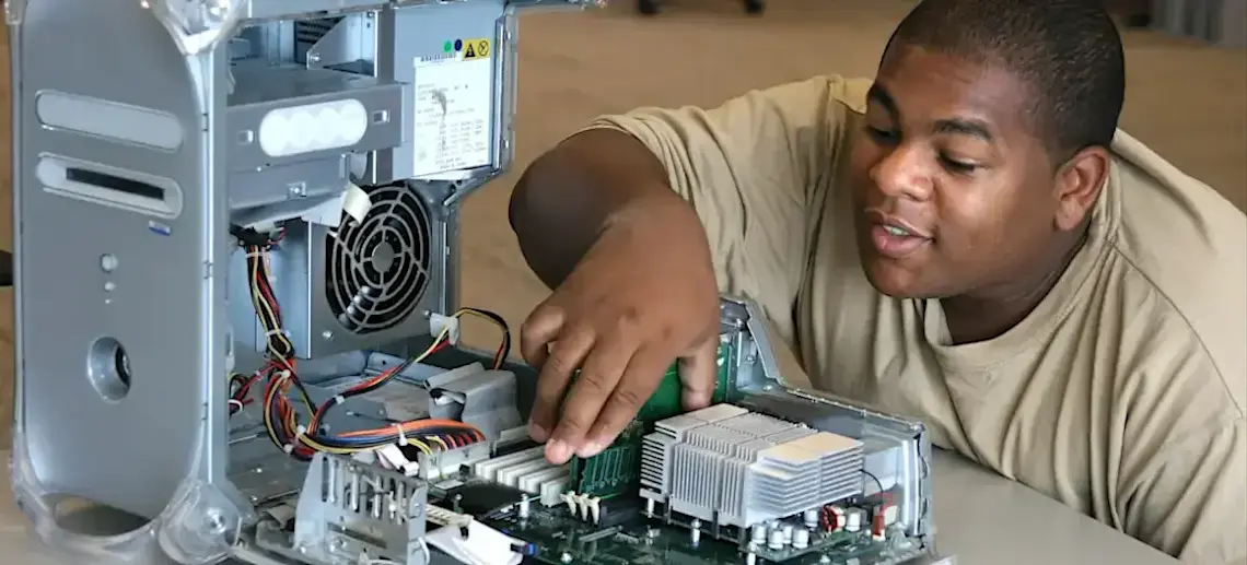 [Featured Image] An IT specialist examines various computer parts, including the central processing unit.   