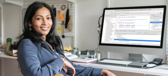 [Featured image] A Southeast Asian woman in a dusty blue top sits with her arm draped over her office chair, smiling at the camera.  