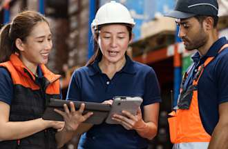 [Featured Image] A logistics specialist meets with employees in a warehouse.