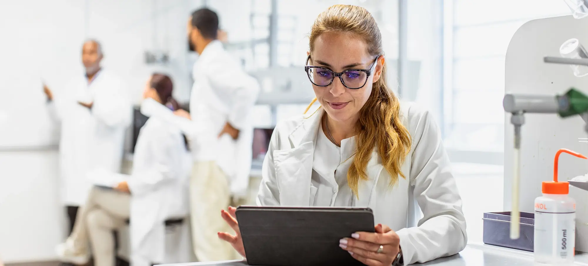[Featured Image] A scientist working in a lab uses a tablet to look over synthetic data. 