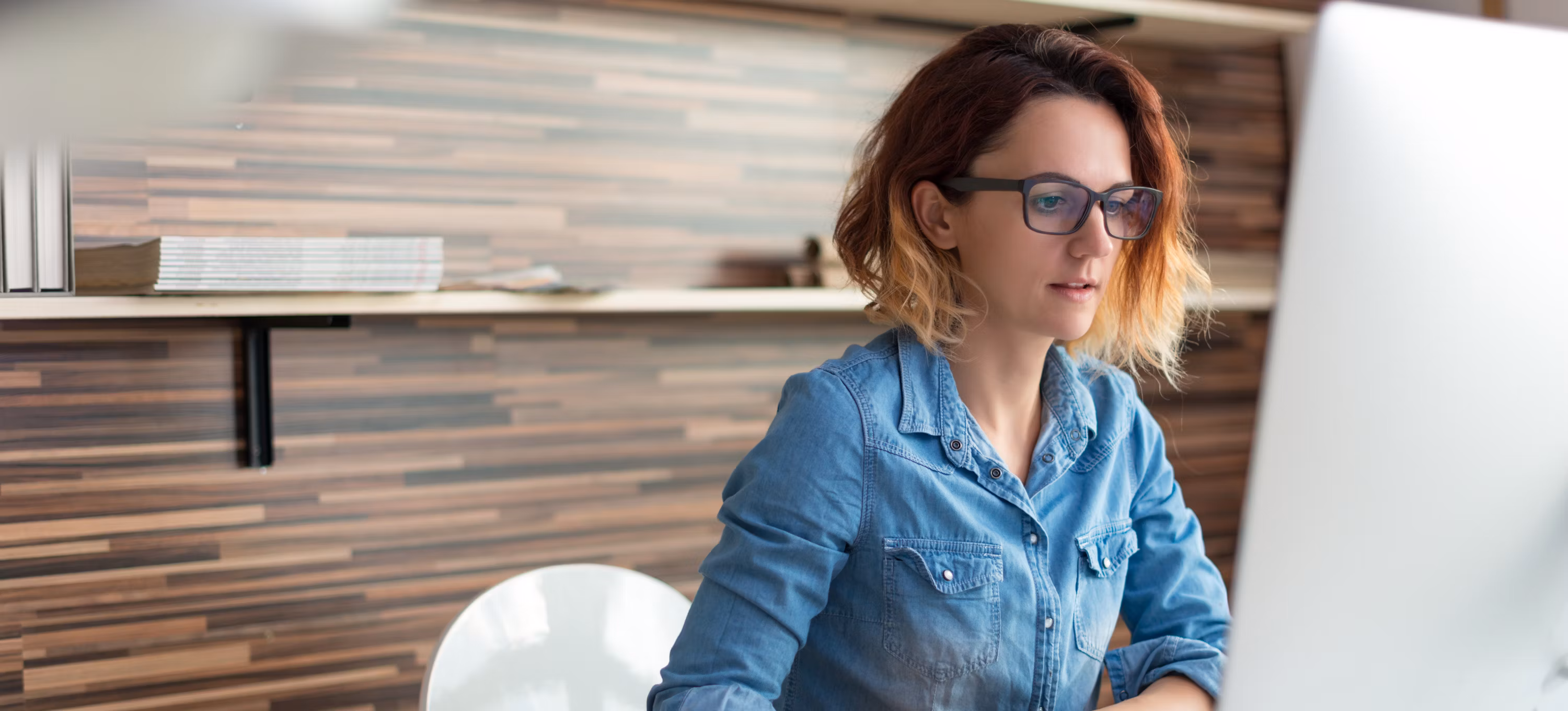 [Image en vedette] Une femme est assise devant un ordinateur et s'informe sur l'intelligence artificielle.