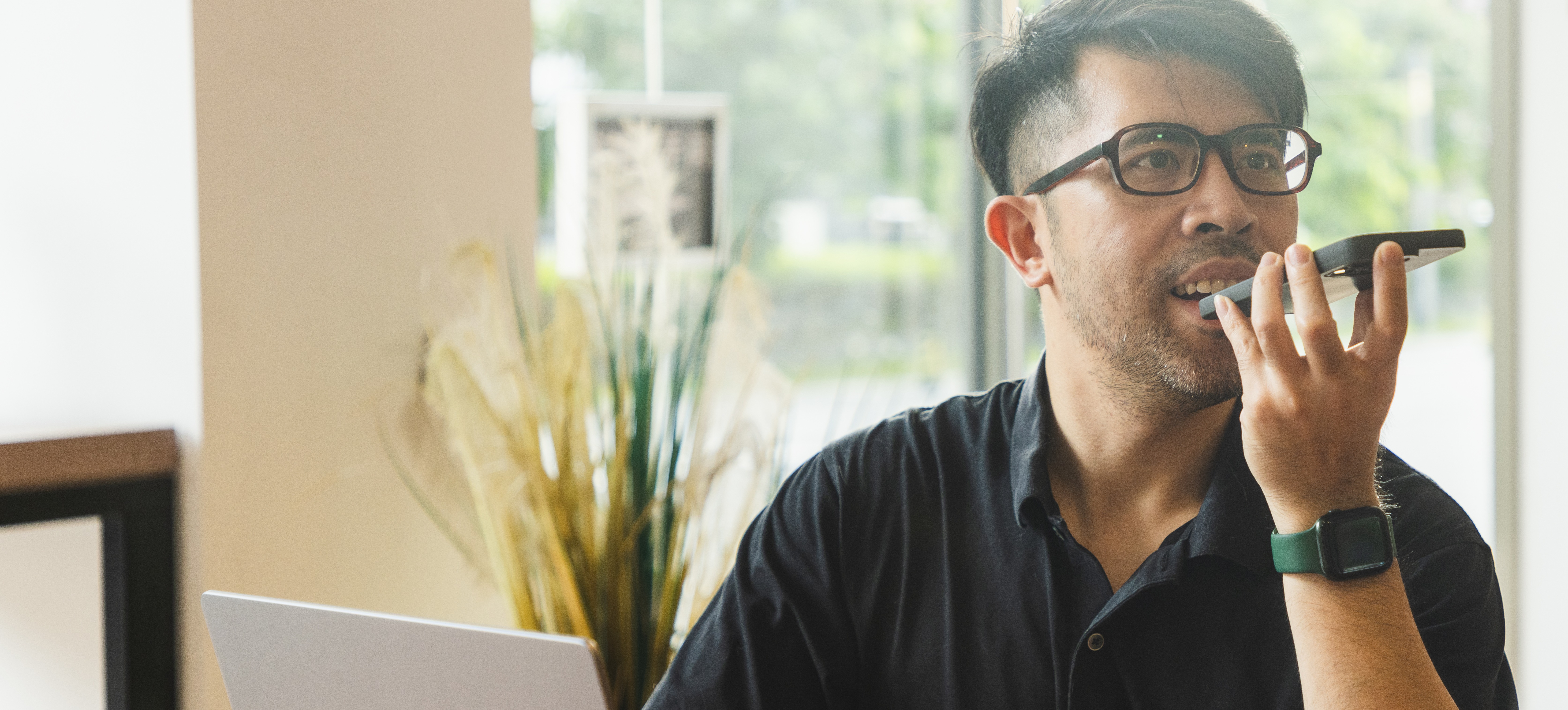 [Featured Image] A businessman using natural language understanding through an AI assistant on smart phone.