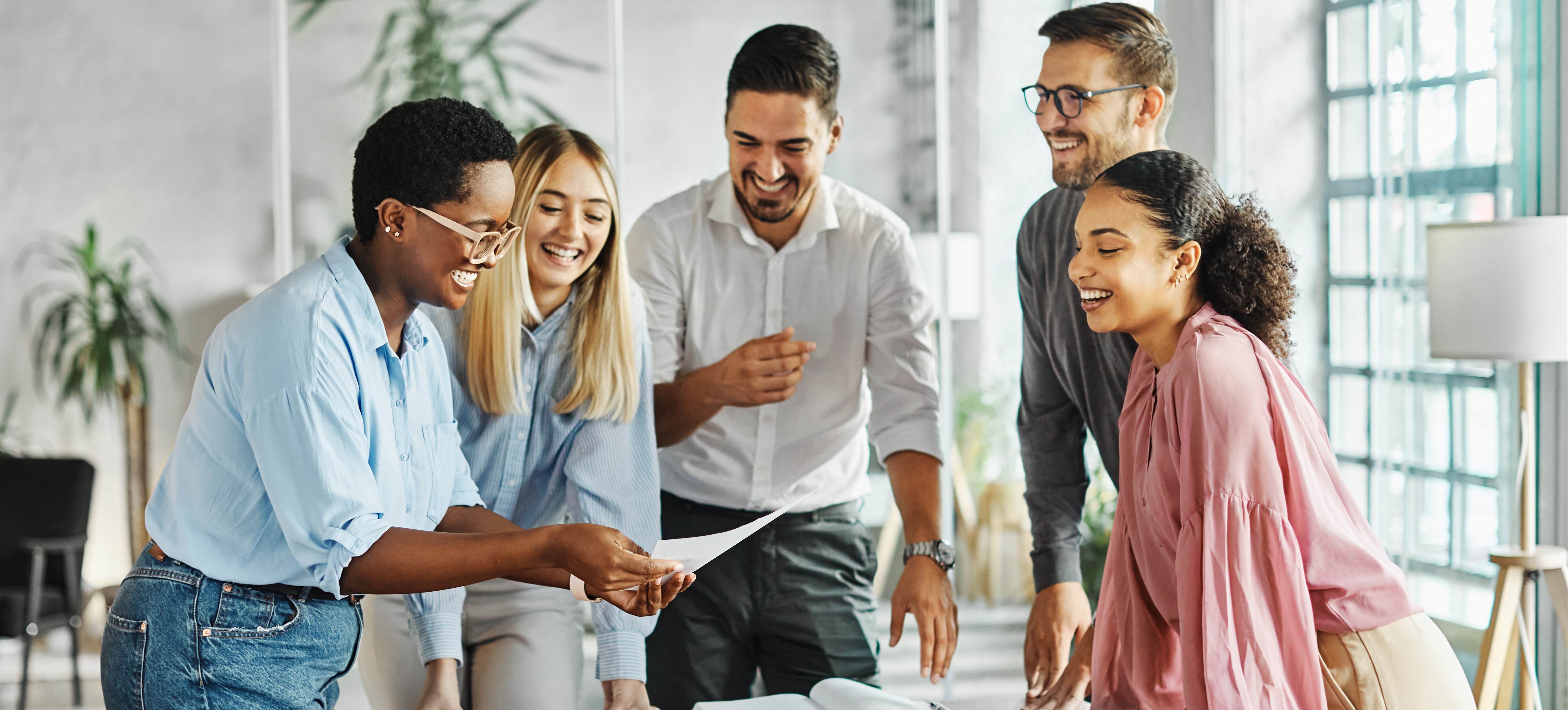 [Hauptbild] Ein Manager leitet eine Diskussion mit zufriedenen Kollegen und nutzt dabei transformative Führung, um positive Veränderungen zu bewirken.