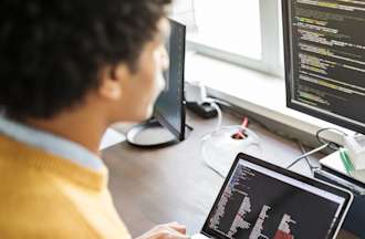 [Feature image] Person examining data on two separate computers