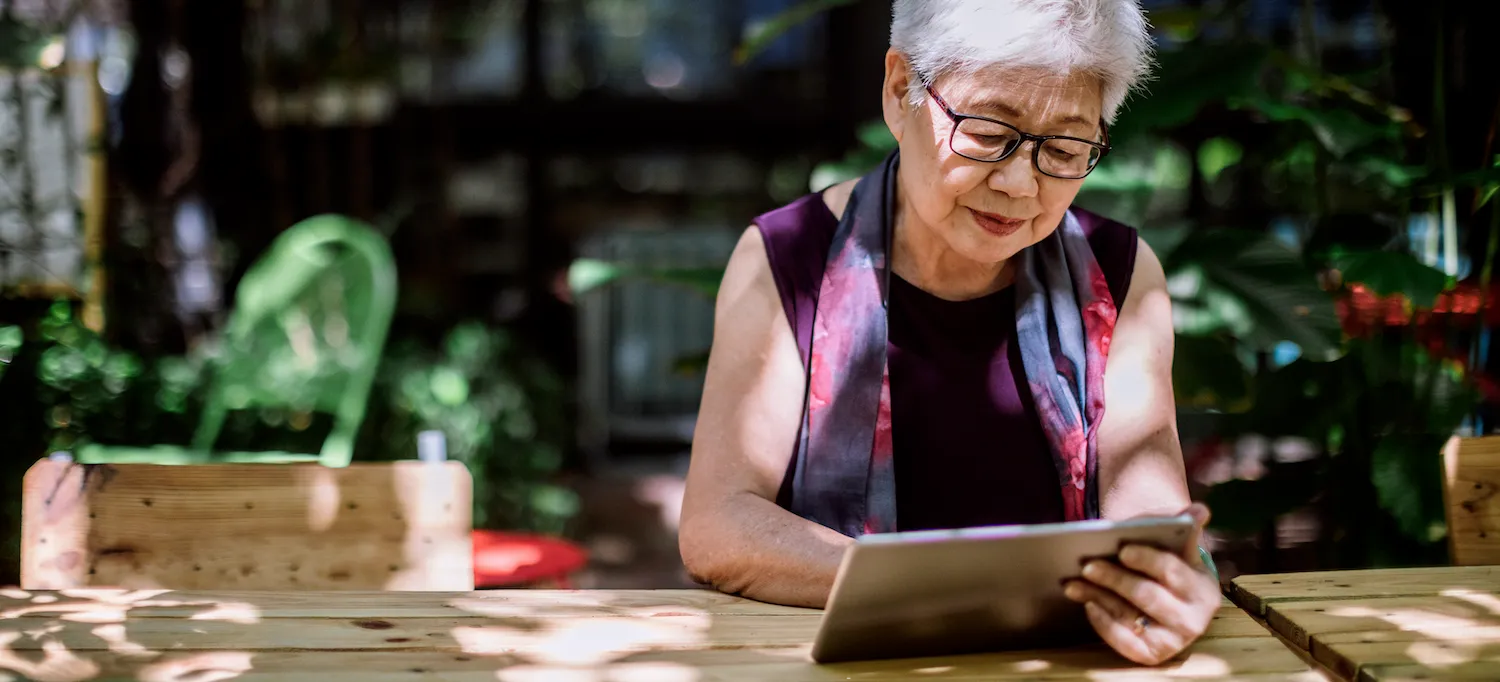 [Featured Image] A person sits outside at a wooden table reading a data analytics book on their tablet device.