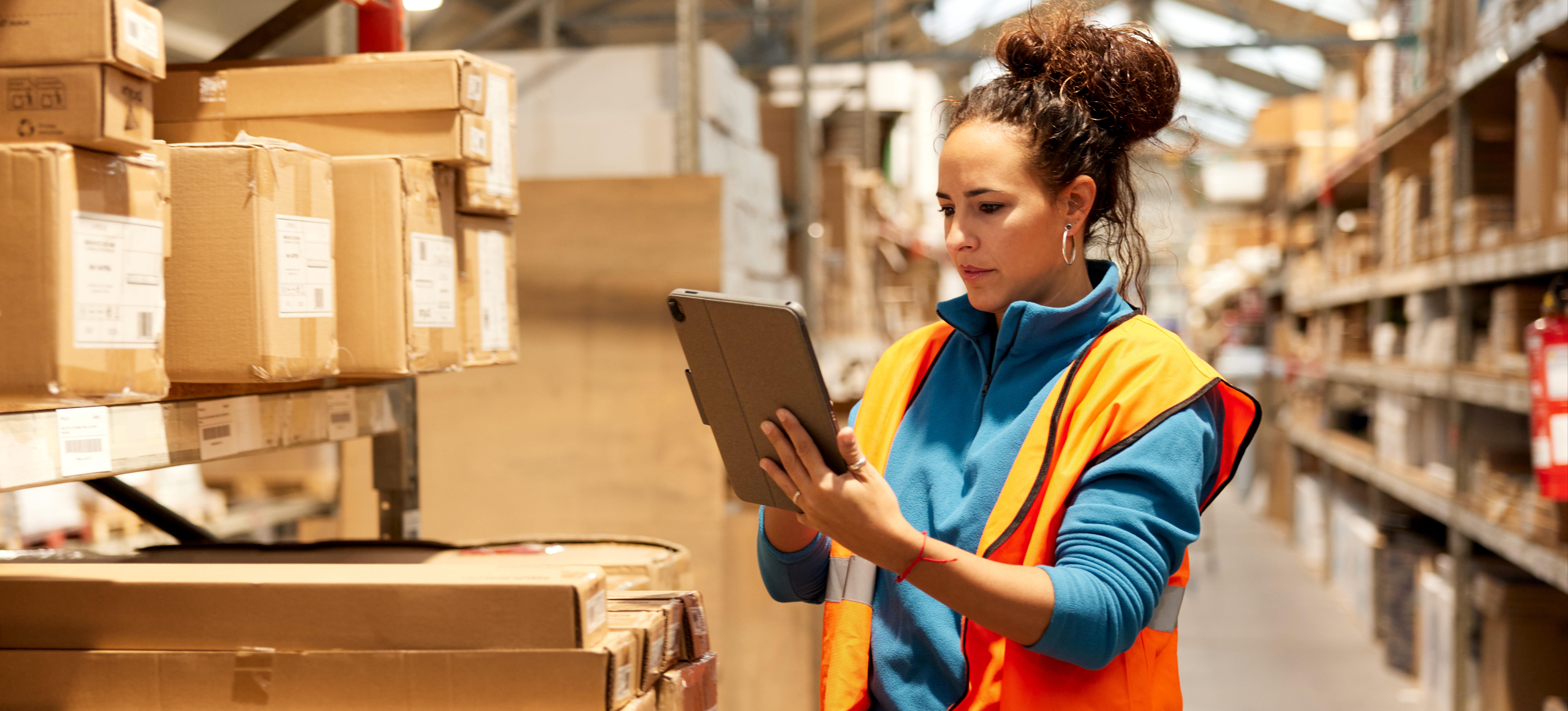 [Featured Image]: A person applies an inventory management system as they take inventory in a warehouse.

