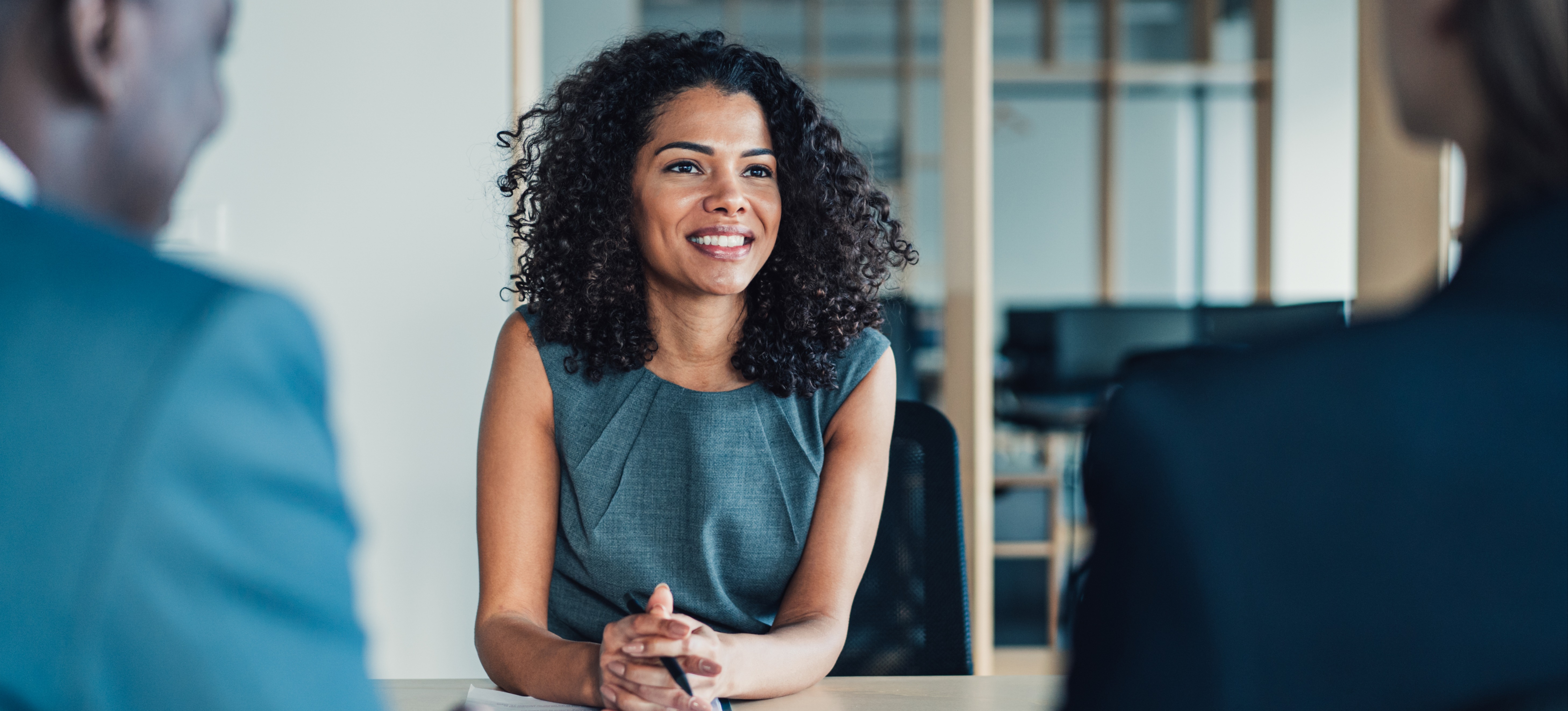 [Featured image] Company employees are asking marketing interview questions to a smiling candidate. 
