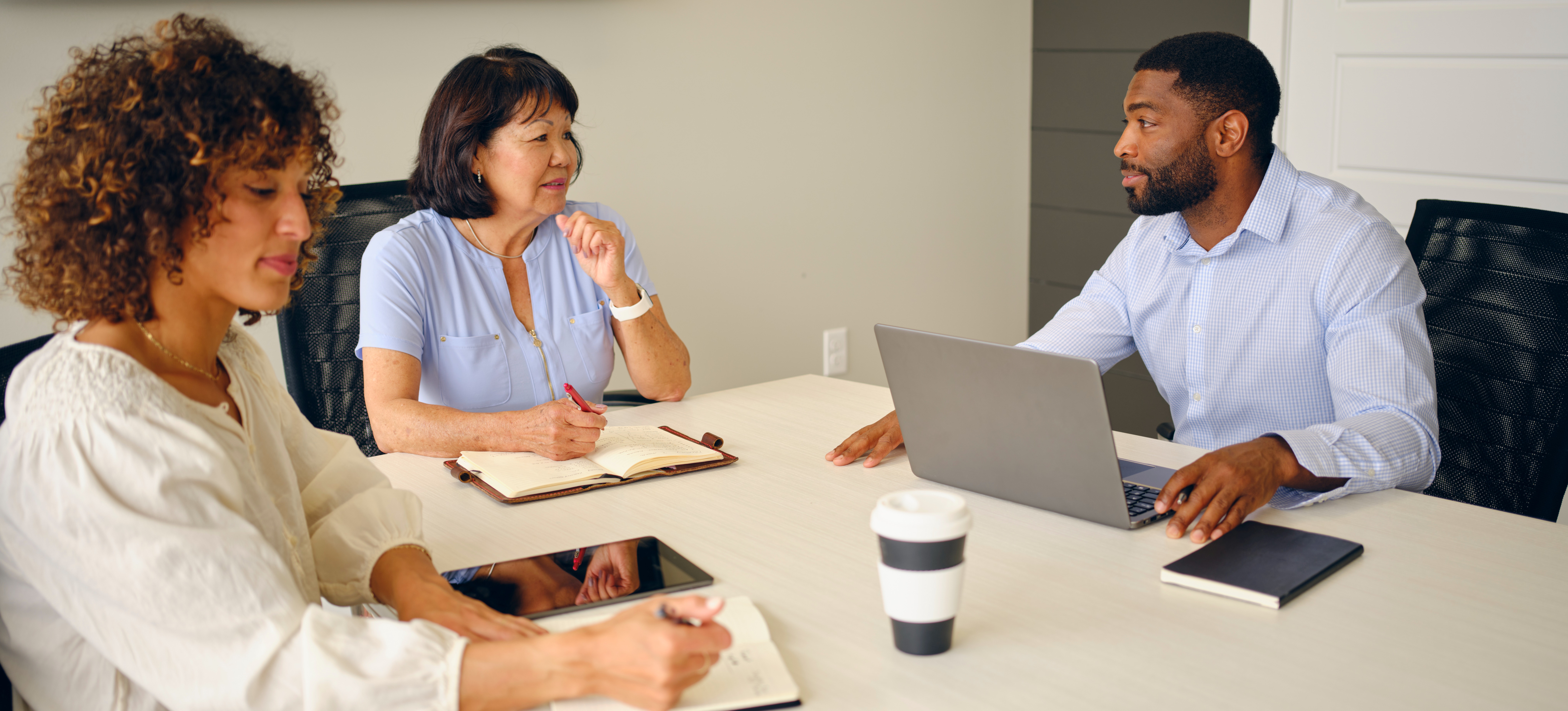 [Featured Image] Professionals in an office environment discussing entry-level project management certification during a business meeting.
