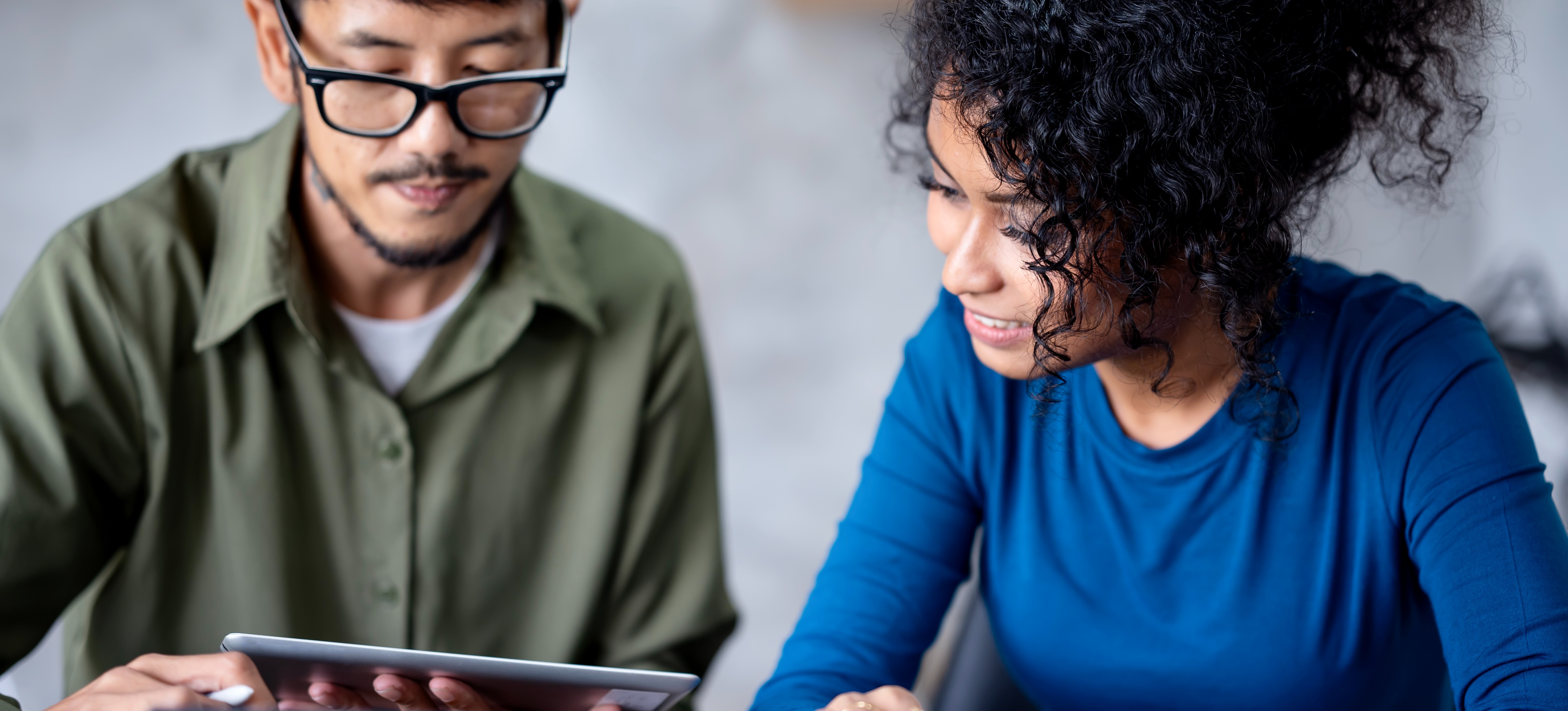 [Featured image] Two cybersecurity specialists look at a tablet and discuss the differences between Comptia A+ vs. Security+ certifications.
