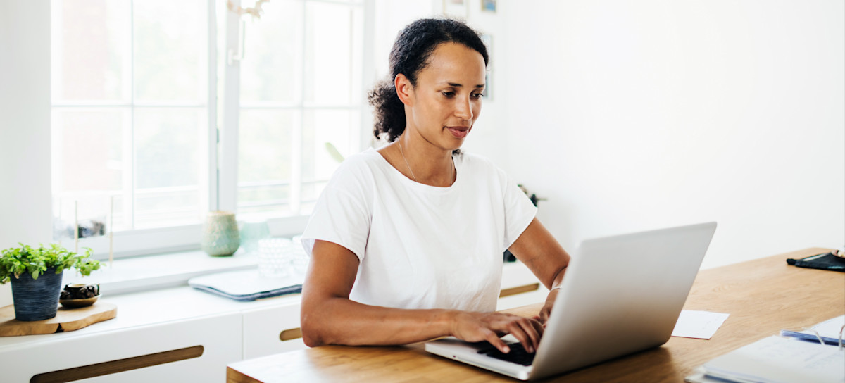 [Featured image] A person works on their laptop at home, preparing to earn the TOGAF certification.
