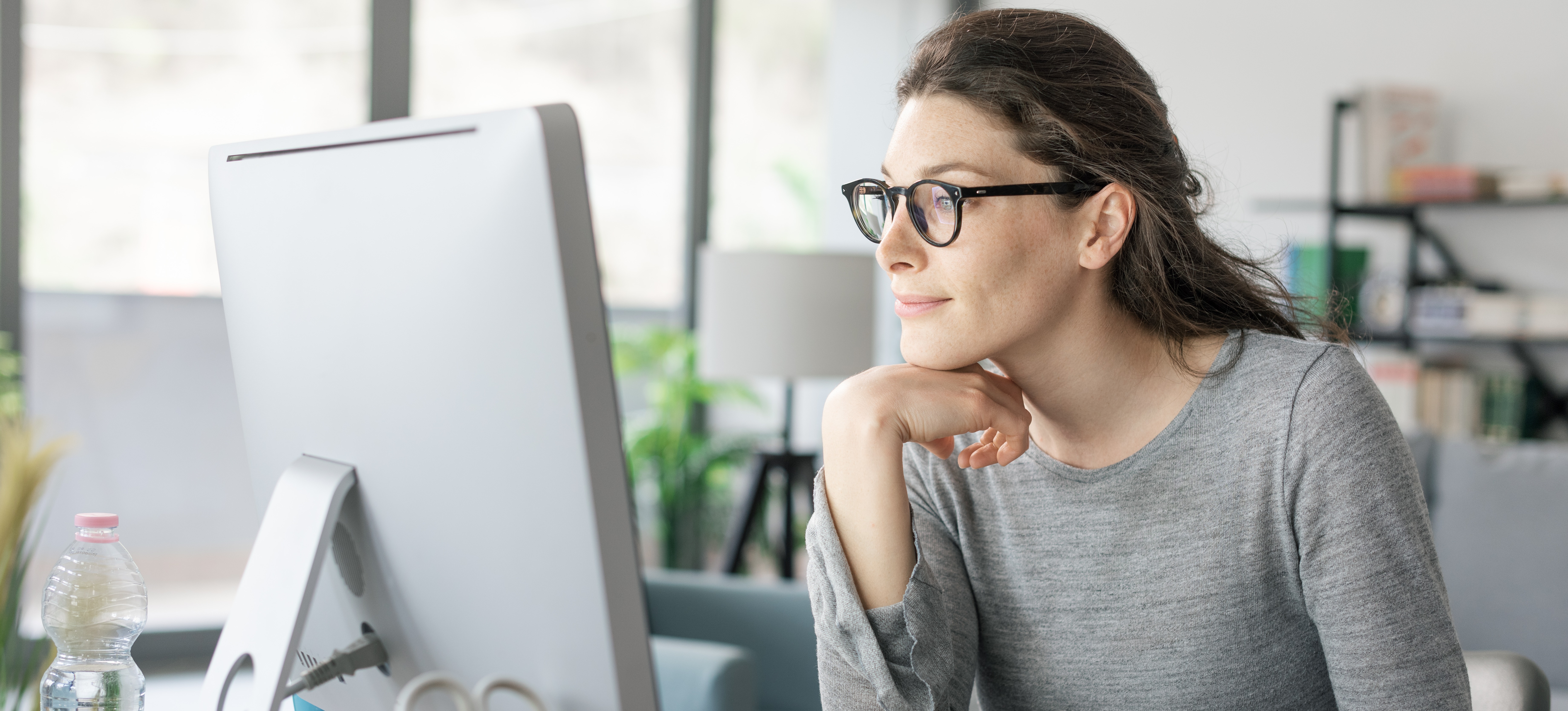 [Image en vedette] Un professionnel souriant améliore ses compétences en matière de données devant son écran d'ordinateur.