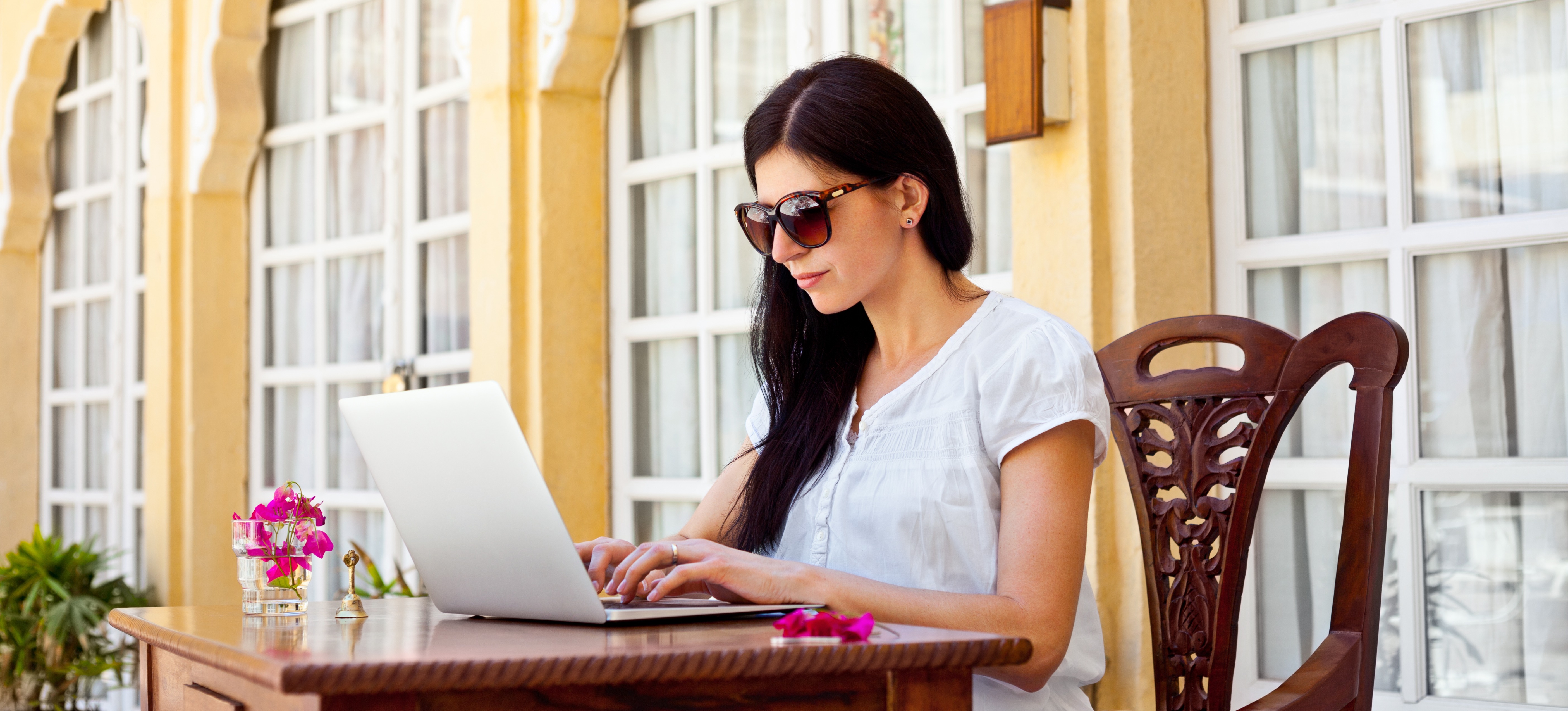 [Featured Image]: A person works on a laptop as they write a project manager cover letter before starting a job search.

