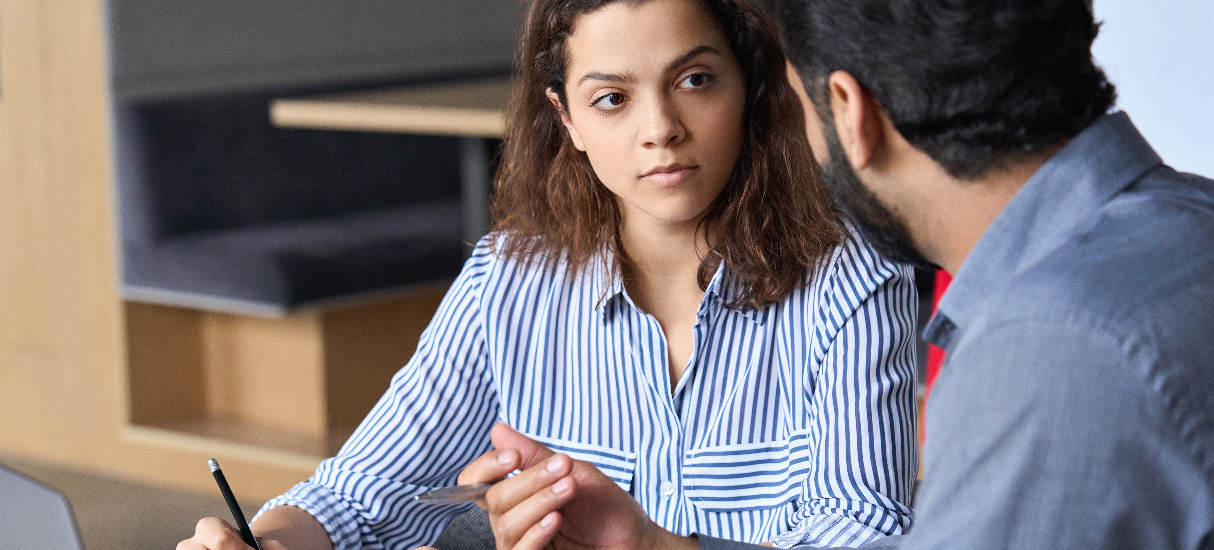 [Featured Image] A man sits with a women for an interview at a table with a laptop. They are discussing finance interview questions.