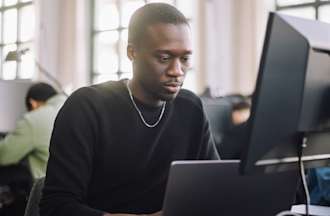 [Featured Image] A data scientist works on a desktop computer in an office.