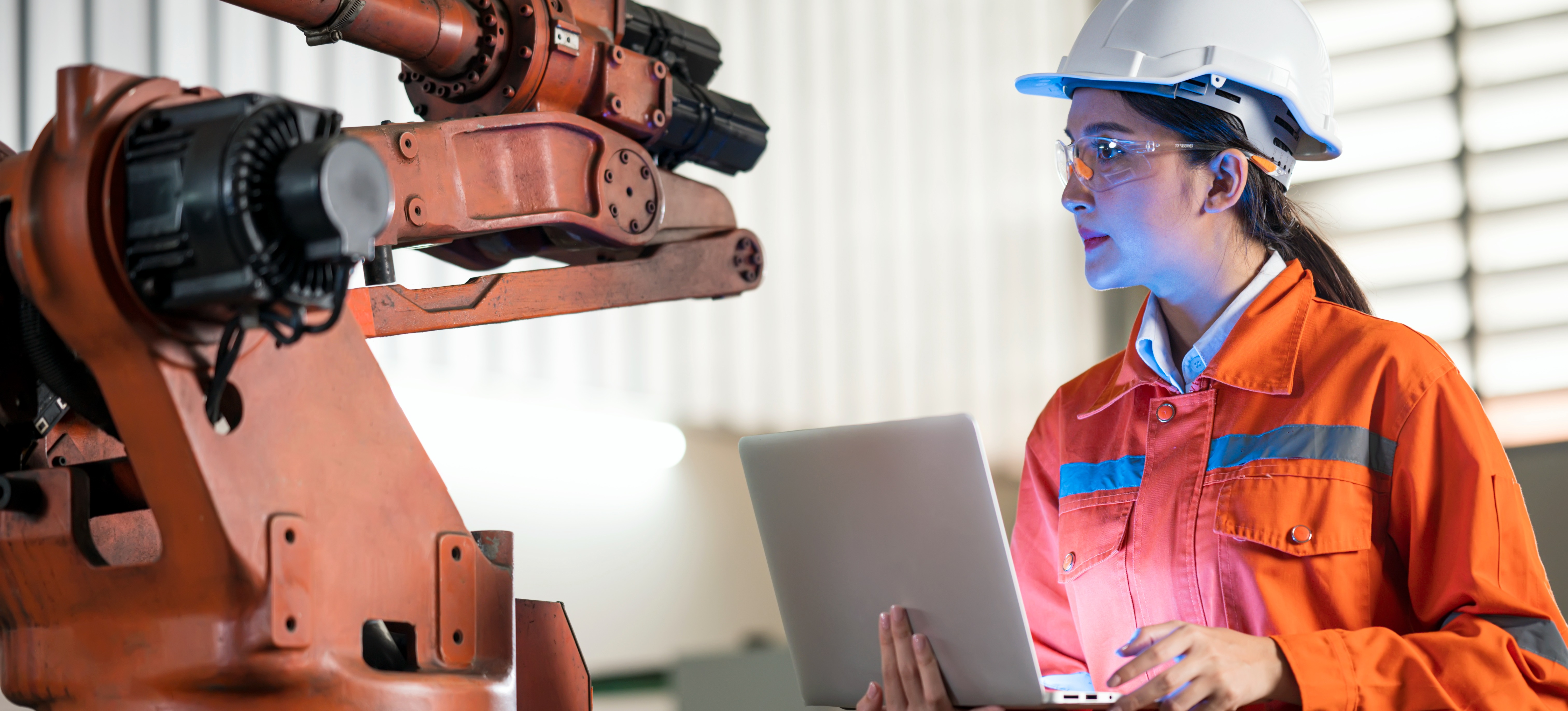 [Featured Image] An electrical engineer with a laptop and protective gear examines robotic arc welding sensors.
