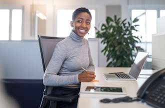 [Featured Image] A woman sits at a reception desk.