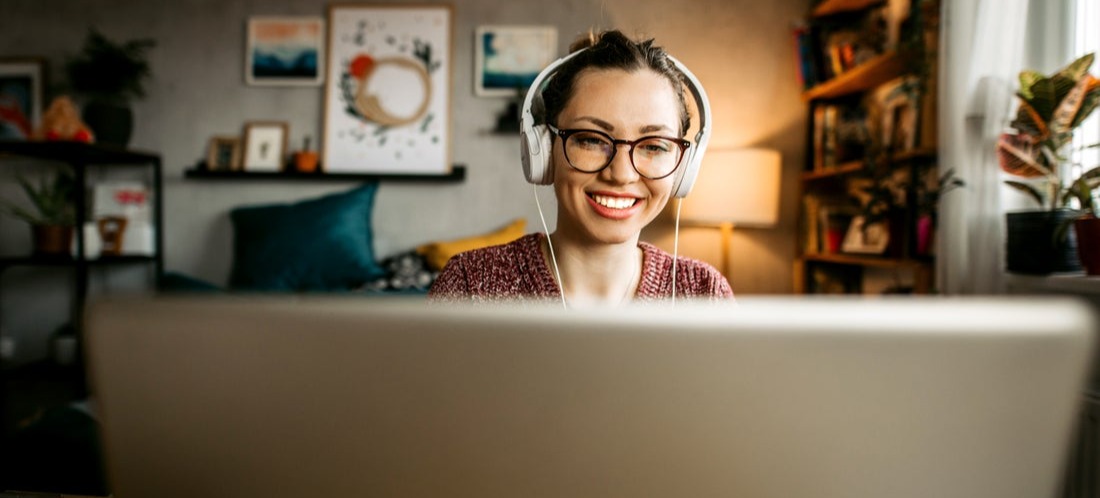 [Featured image] A person listens to music on their headphones while they search how to change their primary market in Shopify on their laptop.