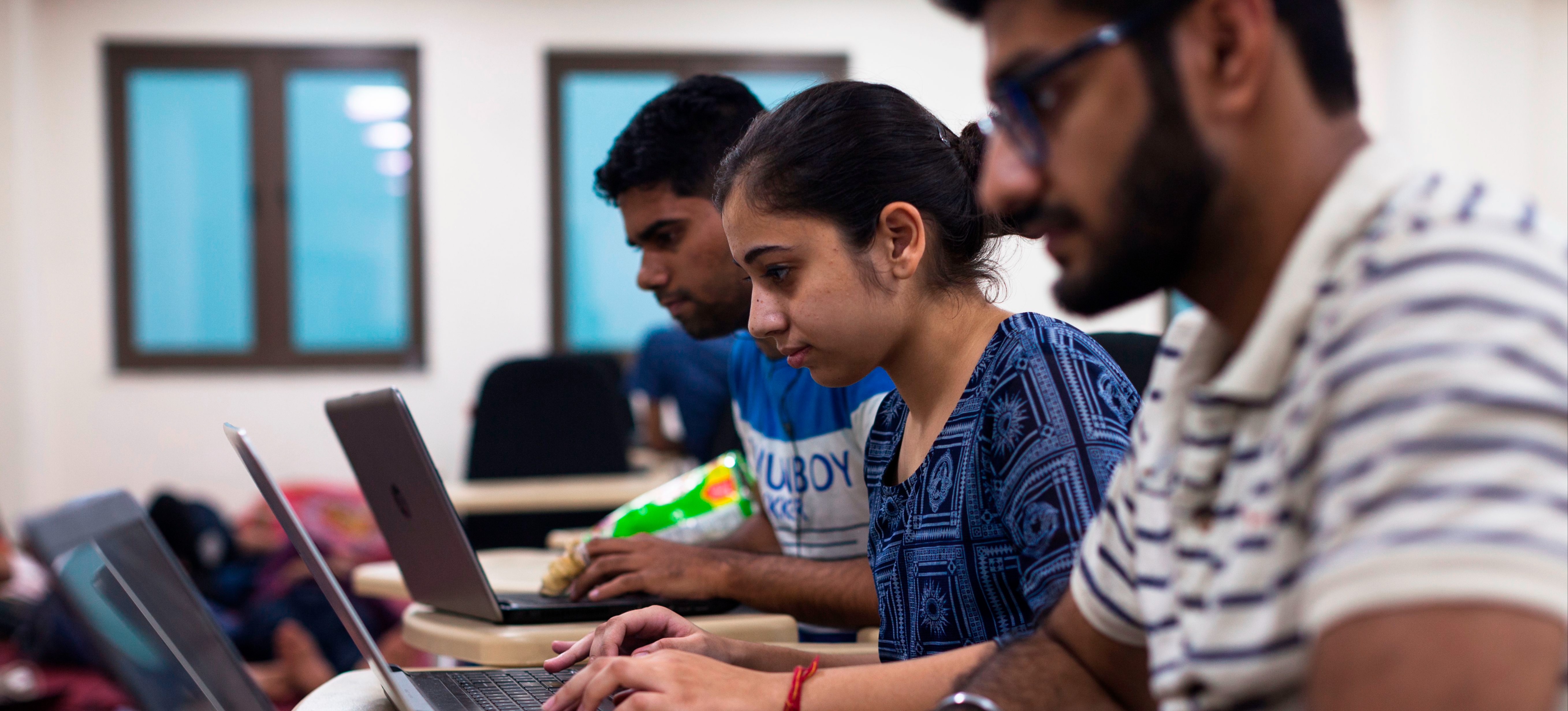 [Featured Image]: A team of software developers engage in a step in the software development cycle as they collaborate on a project.
