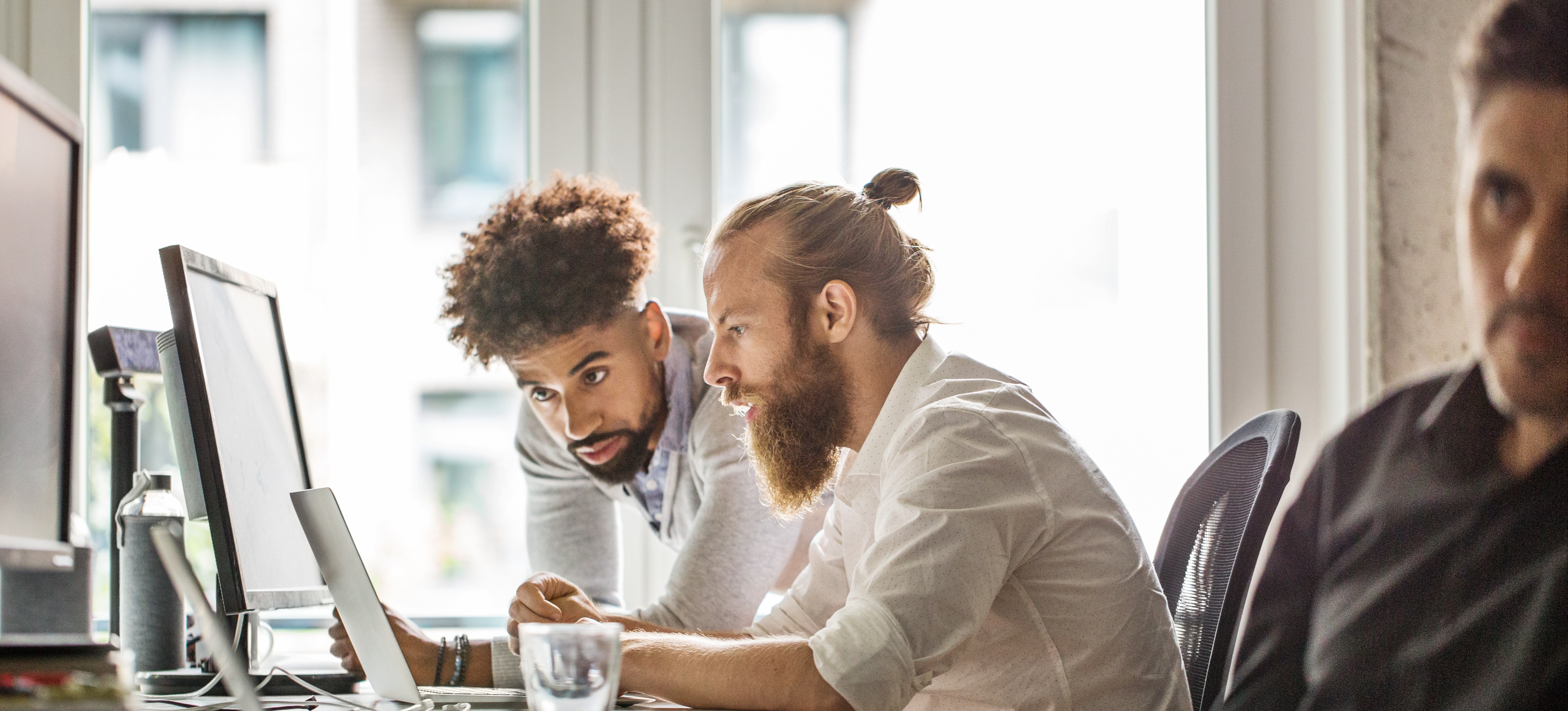 [Feature Image] Two learners collaborate on a project designed to measure generative AI’s impact on business.
