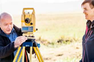 [Featured Image] A GIS analyst visits a surveyor in the field. 