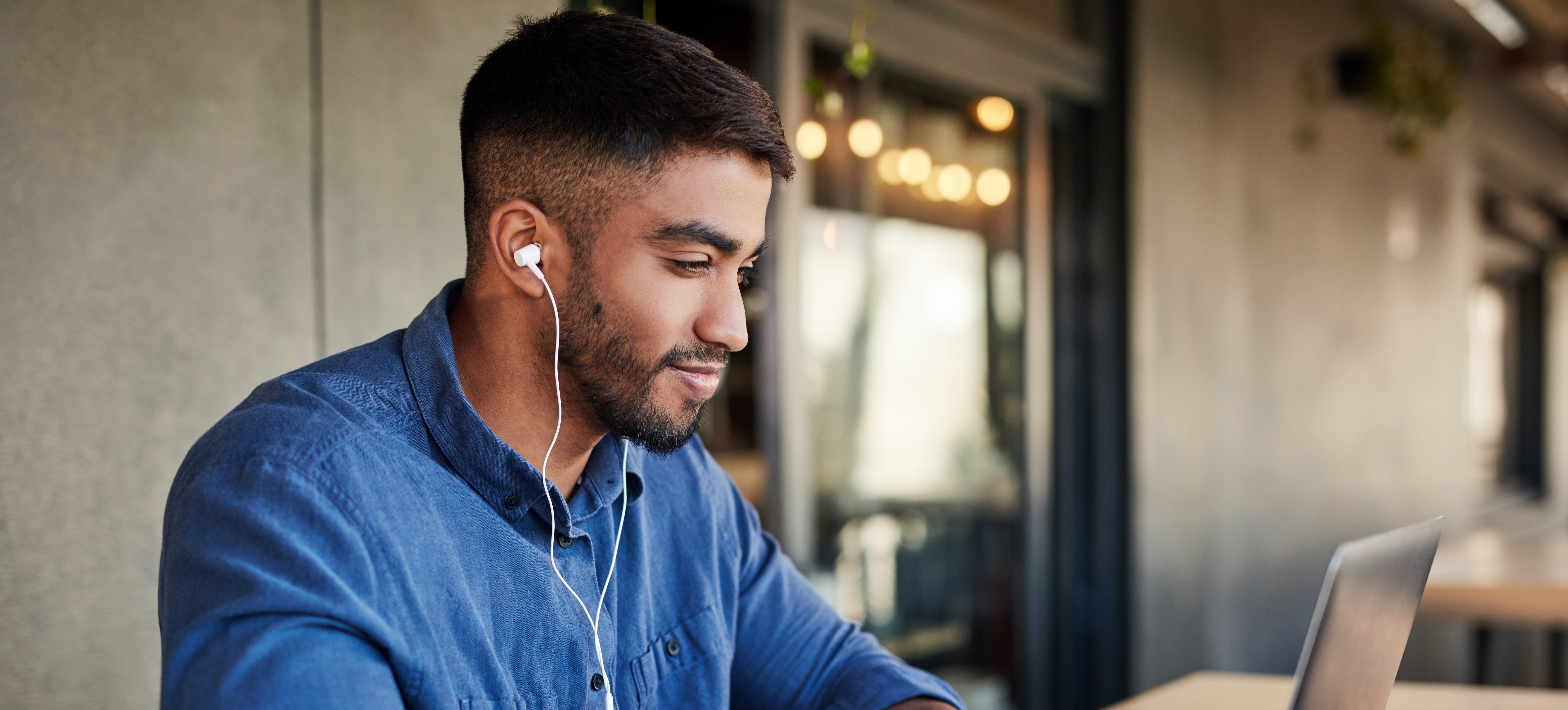 [Featured image]: A student in a cafe uses a laptop as they apply to a master’s degree program.
