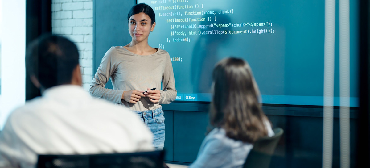 [Featured Image] An instructor leads a discussion about ISO 27001, answering questions from learners about its role as a global standard and how it impacts ISMS.