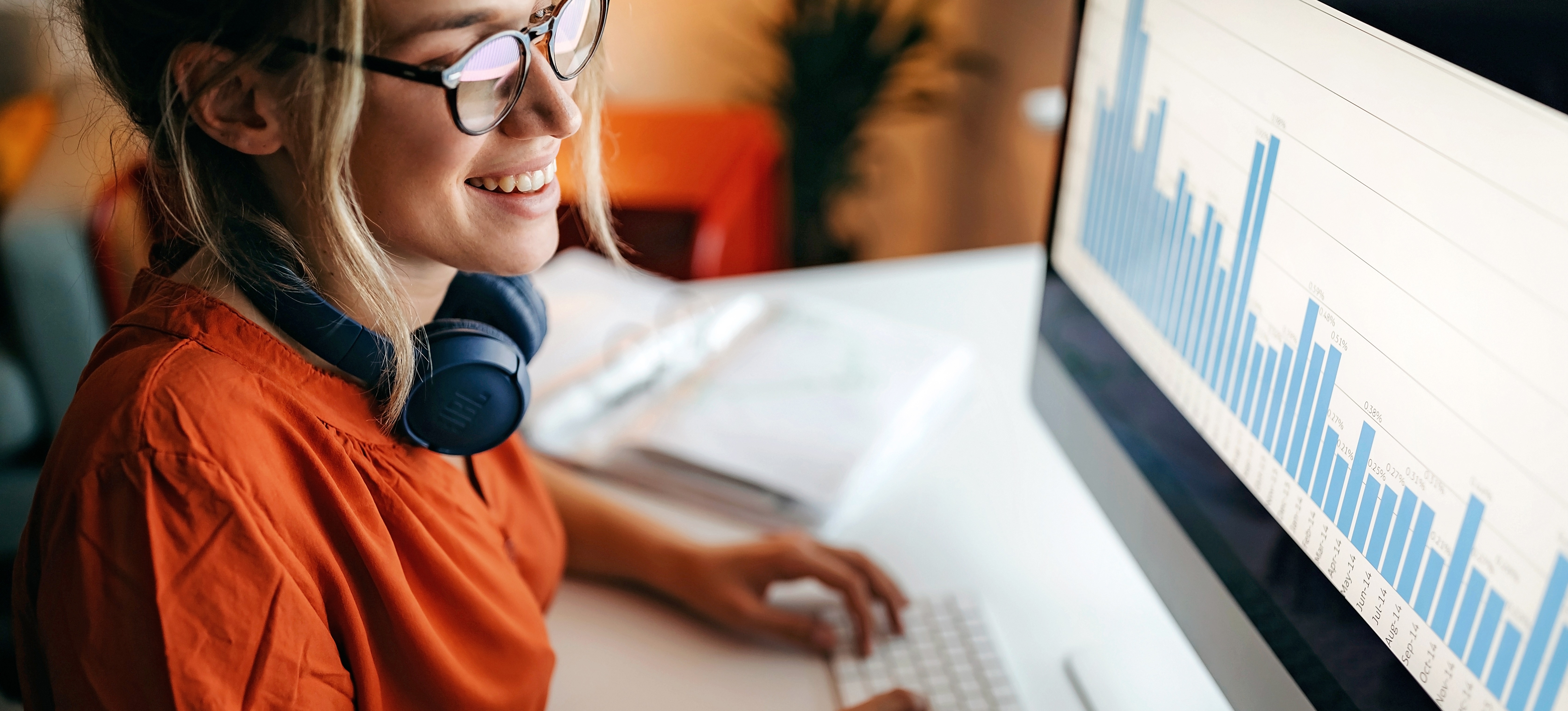 [Hauptbild] Eine Frau, die für den Gehalt einer Datenbankadministratorin arbeitet, sitzt vor einem hellen Computerbildschirm und arbeitet an Daten.