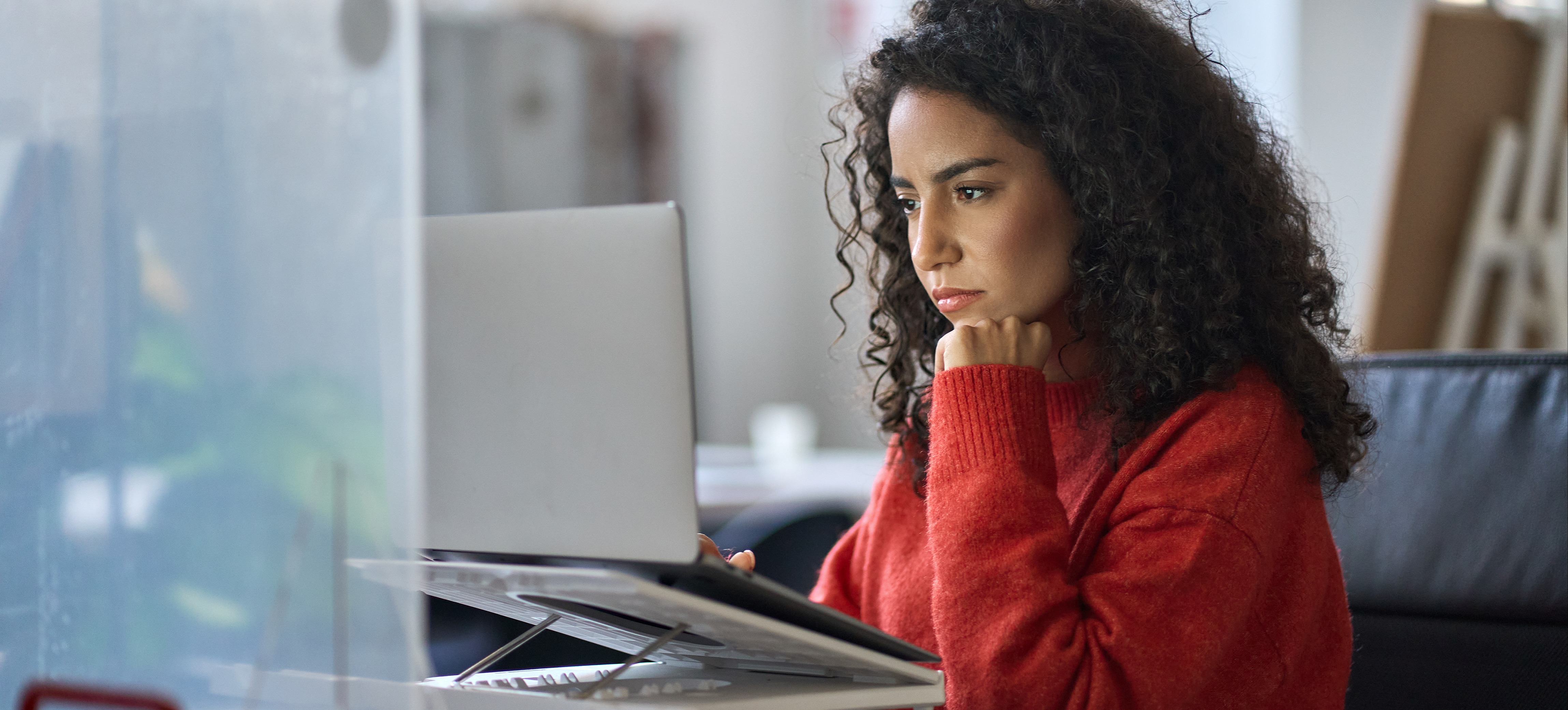 [Featured Image] A penetration tester looks intently at a computer screen in a well-lit office space.
