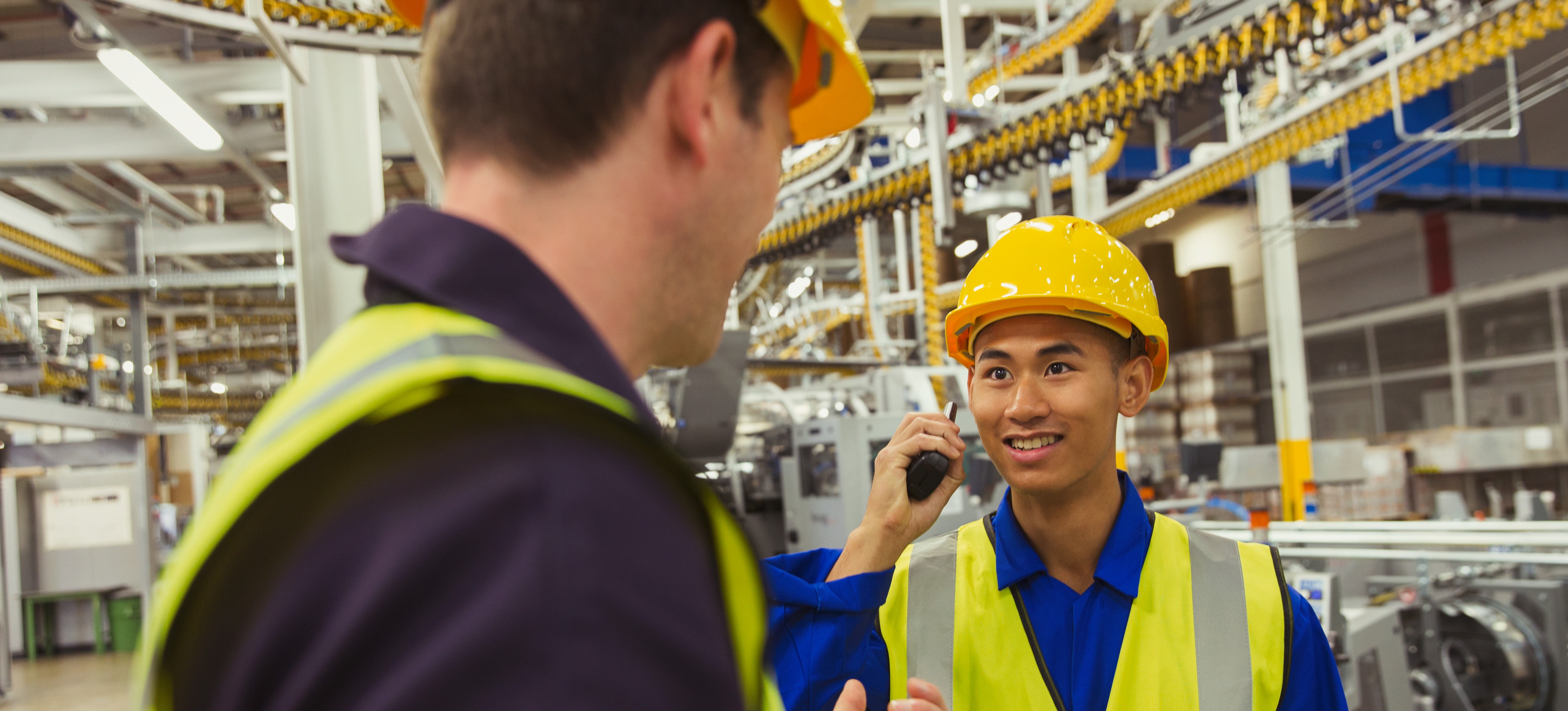 [Featured Image] A development operations manager is meeting with another teammate to discuss a change in the production that will automate an operation.