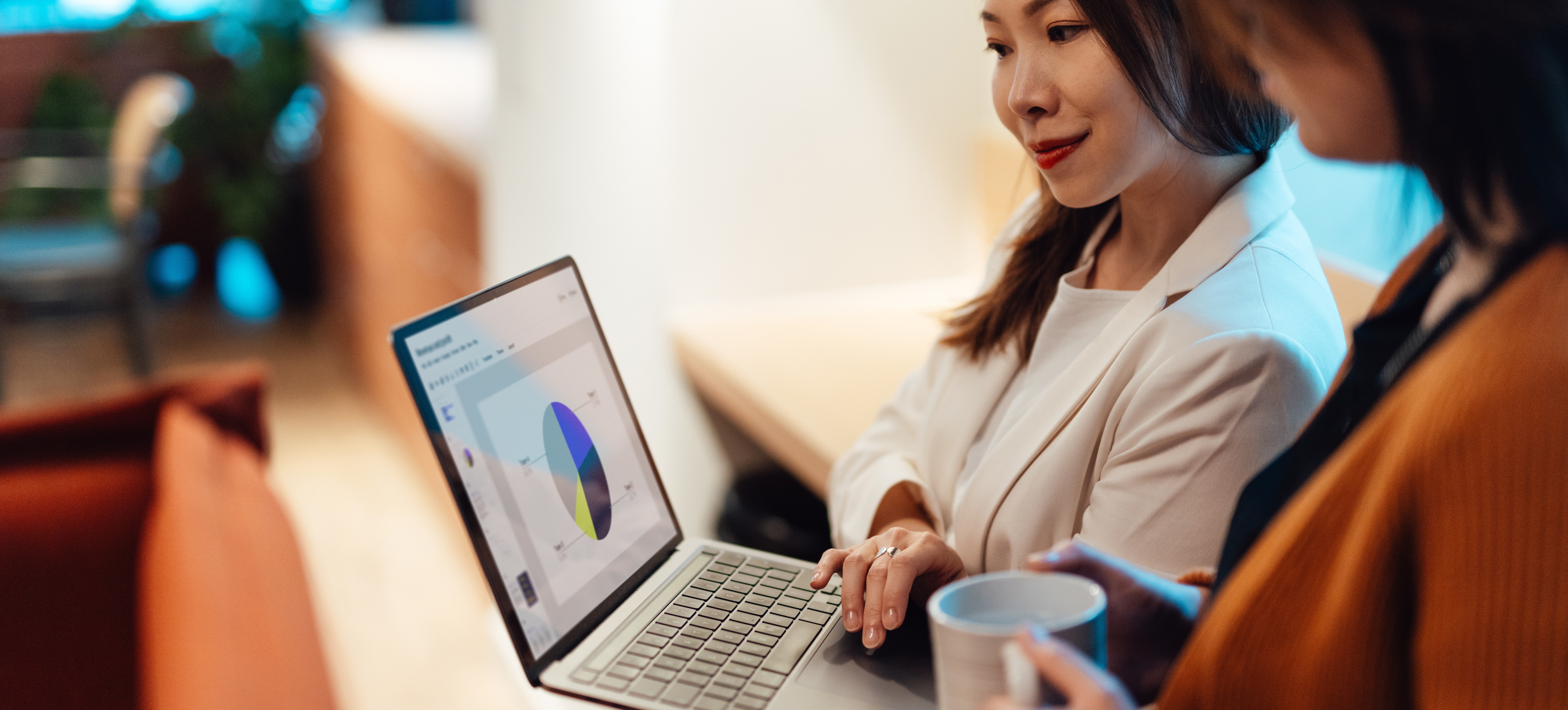 [Image en vedette] Une comptable agréée se trouve dans un bureau et utilise son ordinateur portable pour montrer à son collègue un graphique qu'elle a réalisé à partir de données financières.