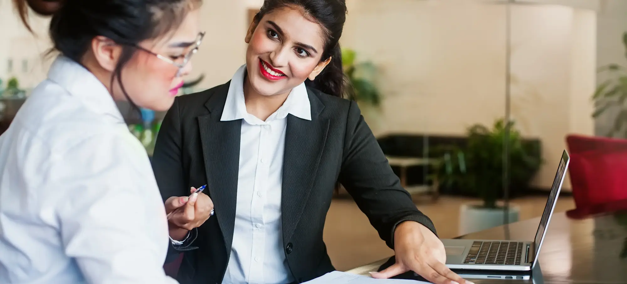 [Featured Image]: A person who earned one of the types of law degrees in India smiles as they review a contract with a client.