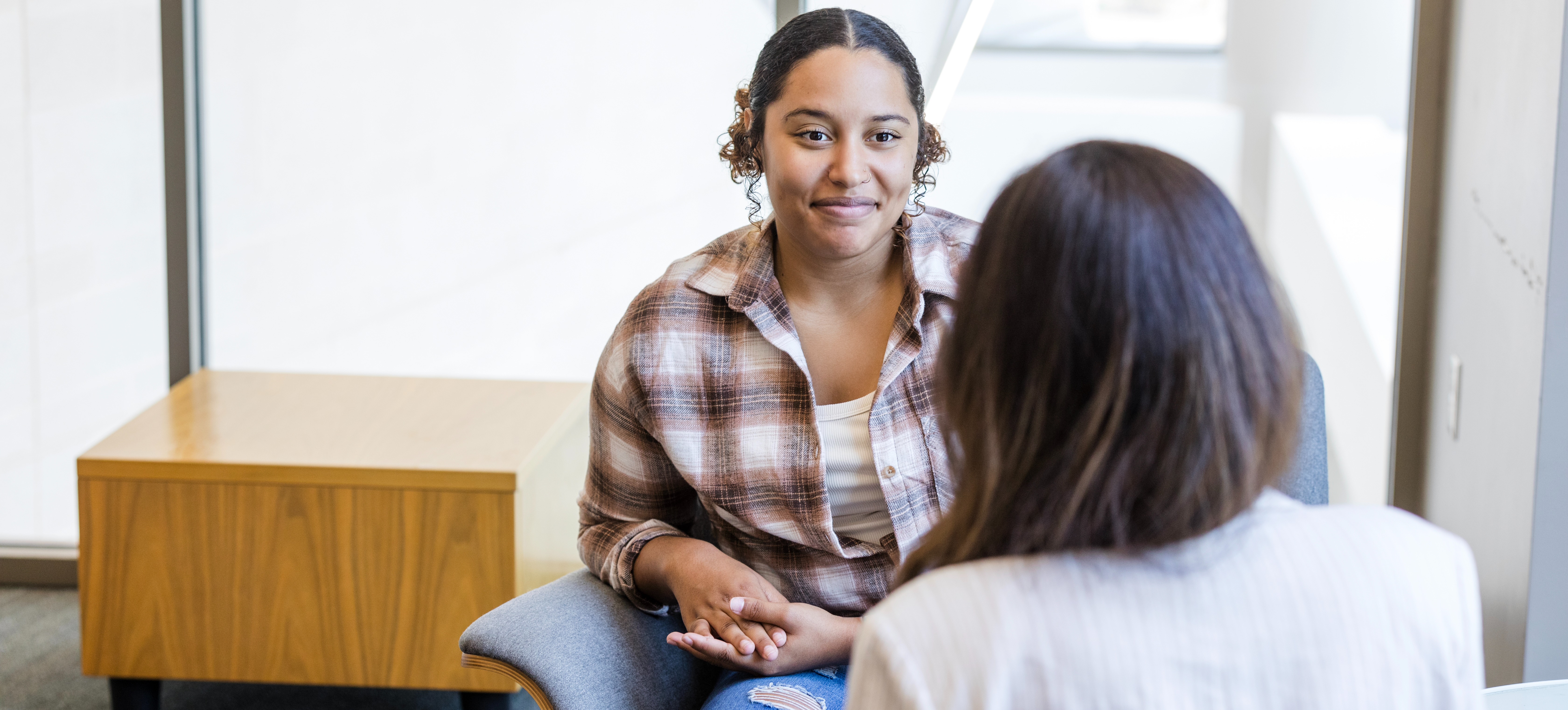 [Featured Image] A person meets with a college advisor to discuss how to improve their GPA after graduation. 
