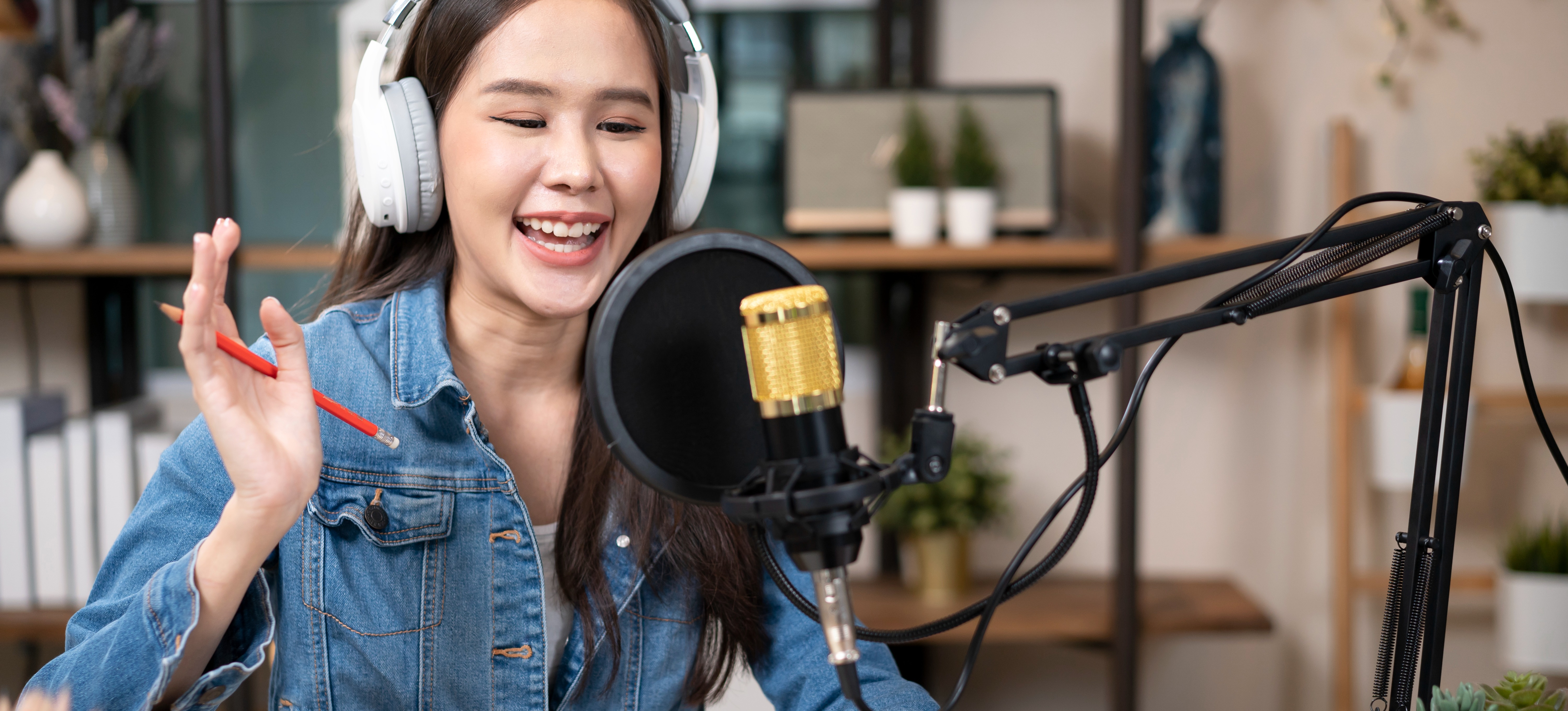 [Featured Image] A sports analyst speaks into a microphone and reports on a major athletic event for a podcast. 