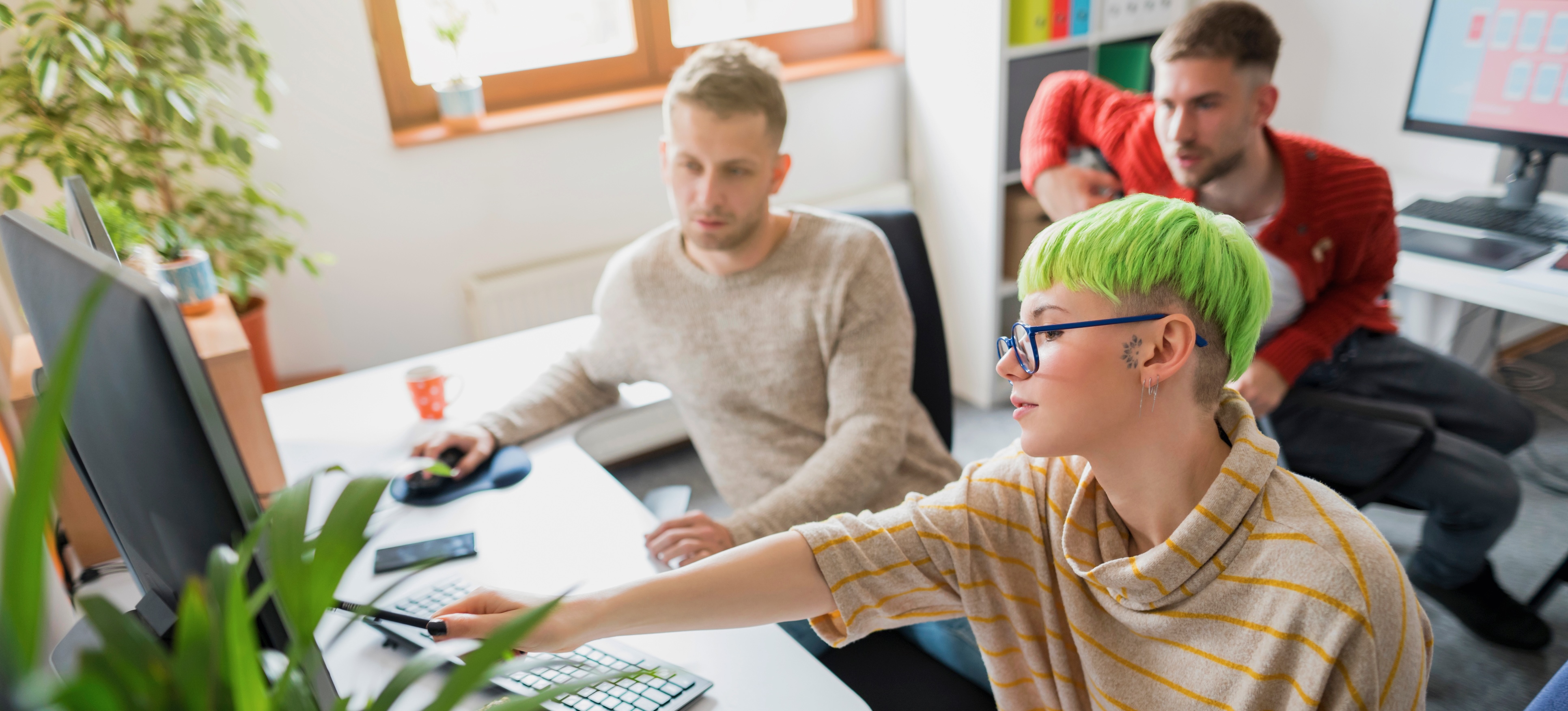 [Featured Image] Three data science colleagues review data on a monitor.