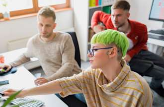 [Featured Image] Three data science colleagues review data on a monitor.