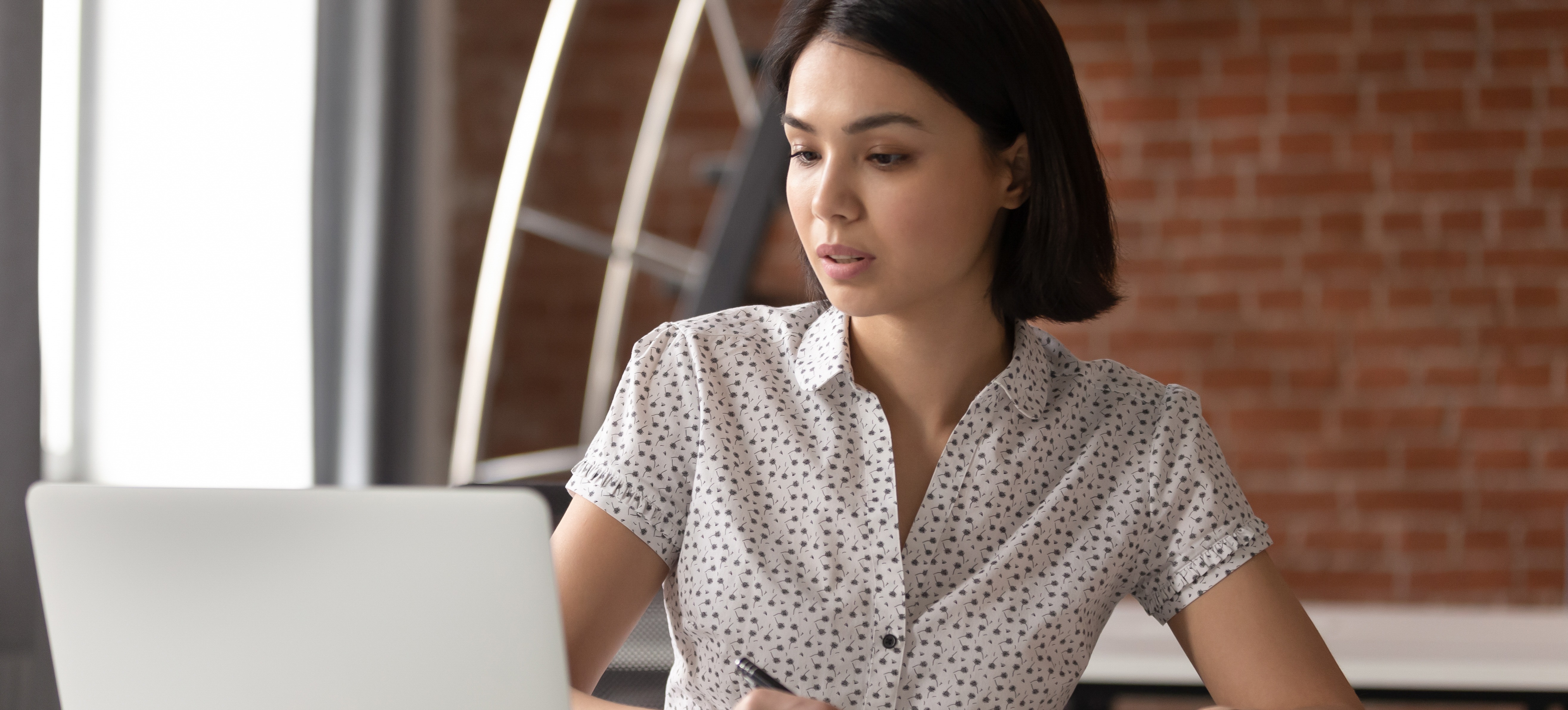 [Featured Image] A woman sits at a laptop and takes an online course on how to learn Power BI.
