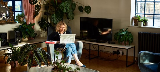 [Featured image] A student is learning about domain name systems on their laptop in their living room.