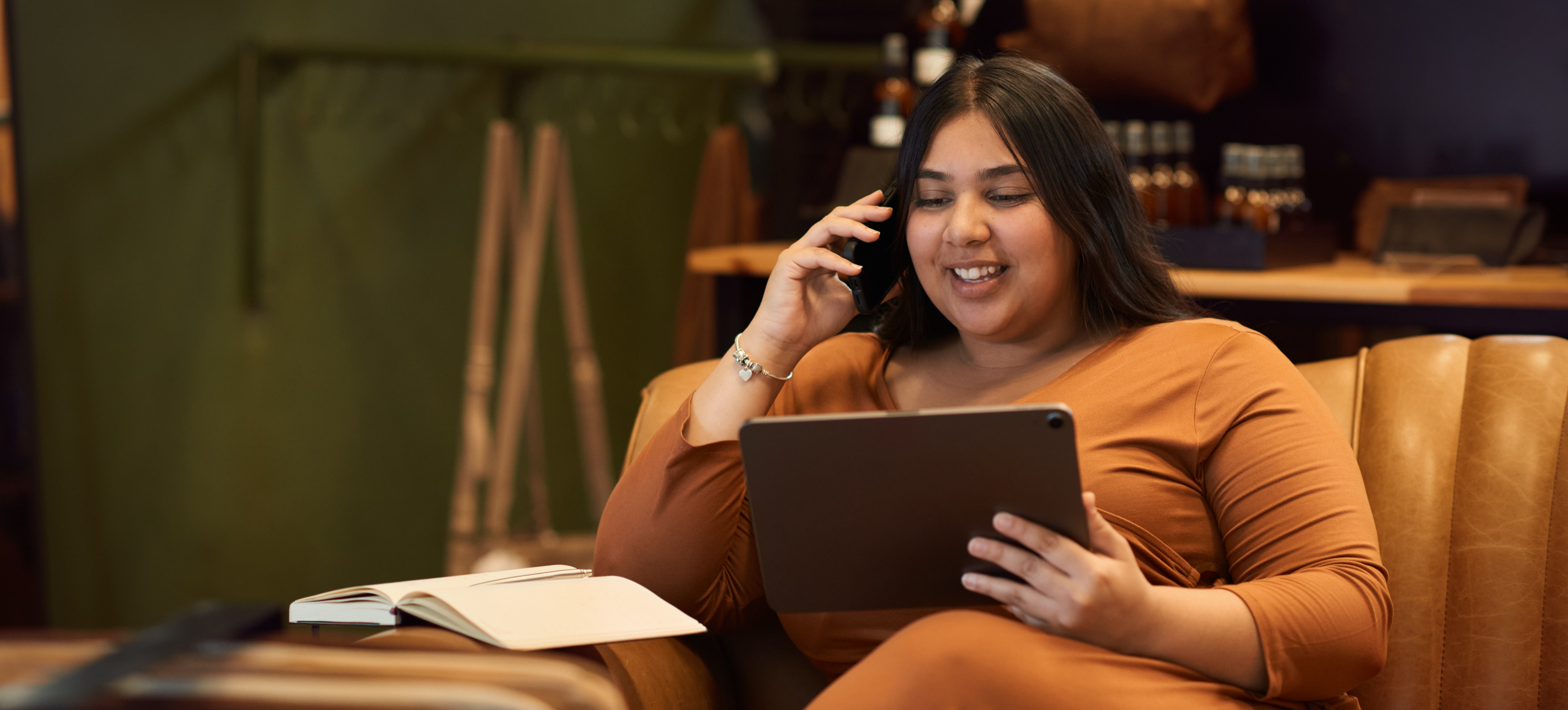 [Featured Image] A product manager takes a phone call while consulting a tablet.
