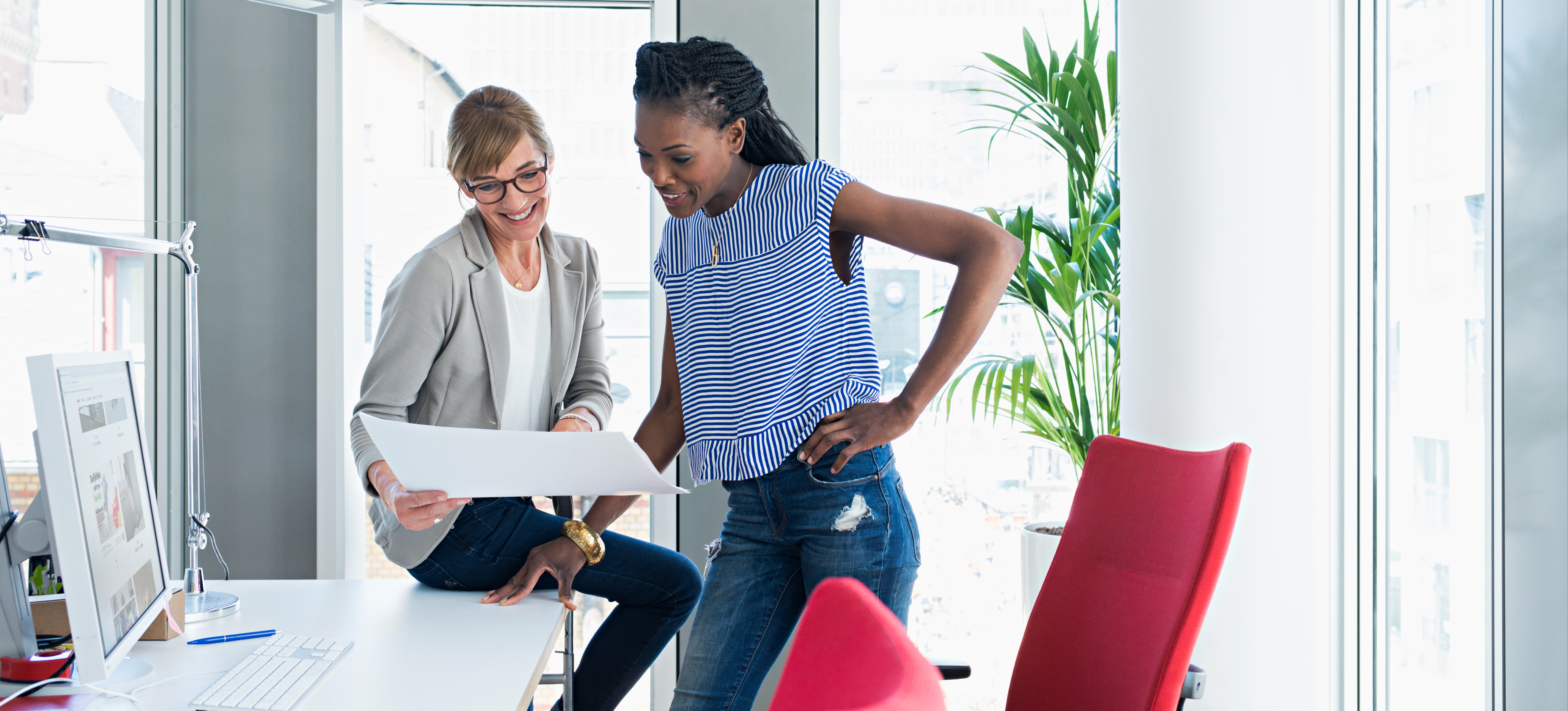 [Featured Image] Two machine learning professionals look over some paperwork in an office and talk about diffusion models.

