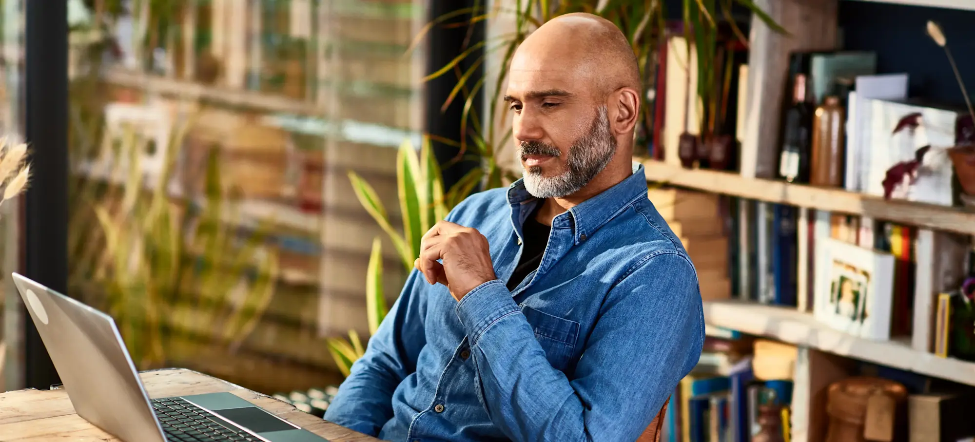[Featured Image] A business owner is sitting at a desk with a laptop furthering their knowledge while getting certified in technology that could benefit their company.

