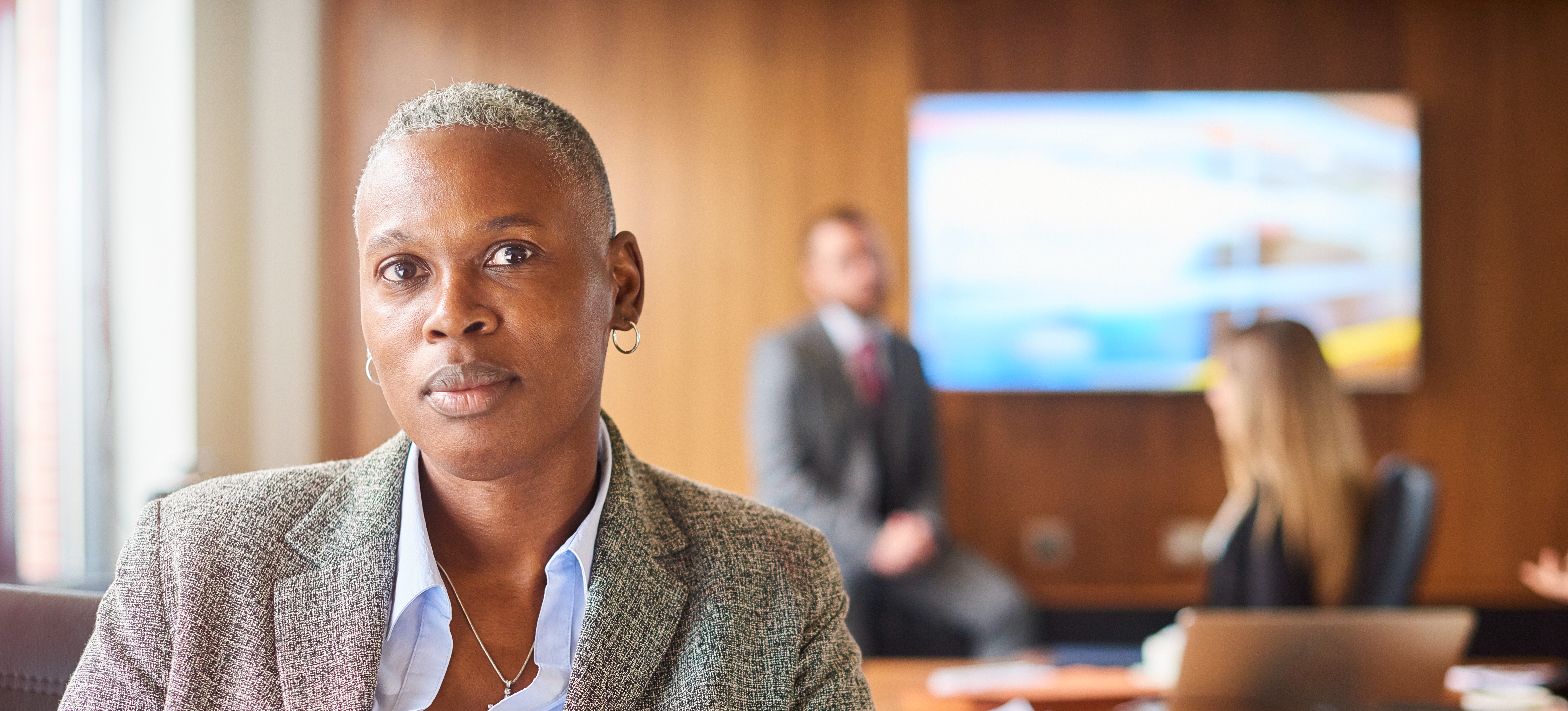 [Featured Image]:  A manager, standing in a conference, preparing to meet with the team to discuss conflict management. 